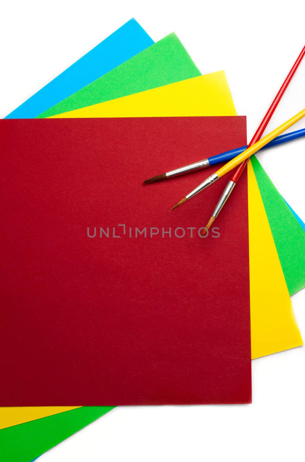 Coloured paper and brushes isolated on white