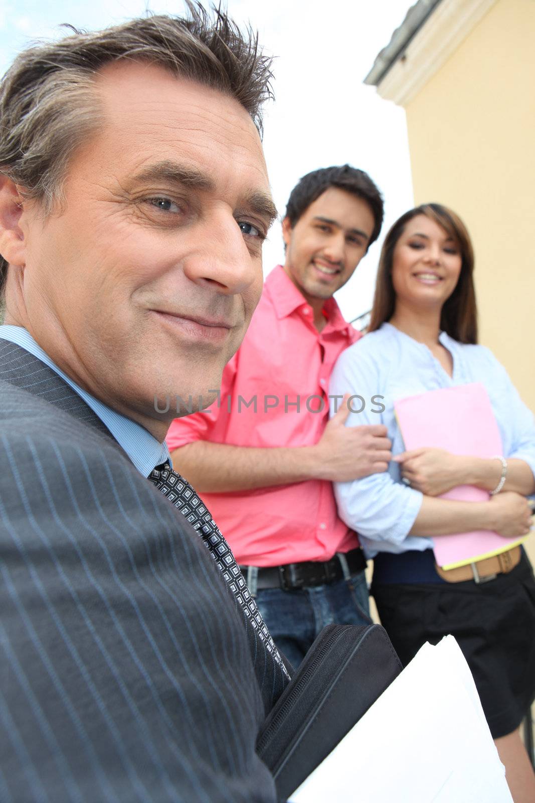 Estate-agent about to show couple round a property