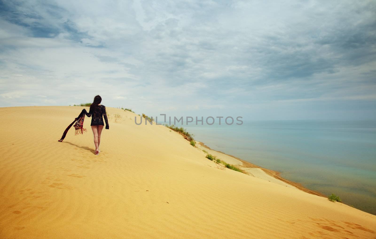 Lonely lady walking in the desert. Vibrant color
