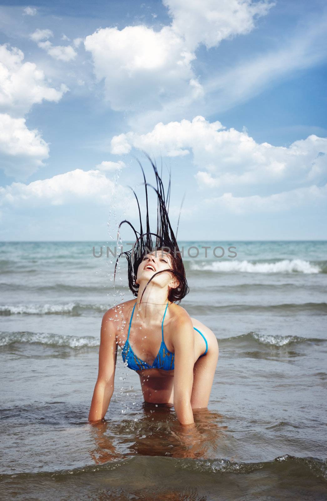 Beach scene with lady in the water moving her hair