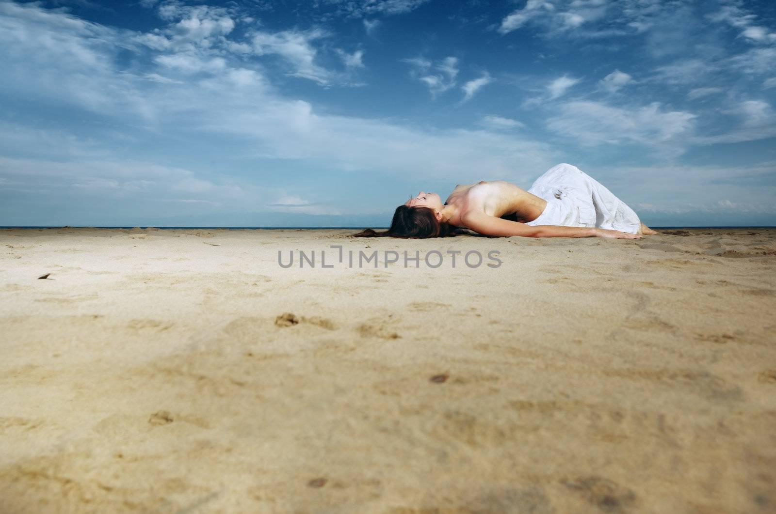 Topless lady laying on the sand at the beach