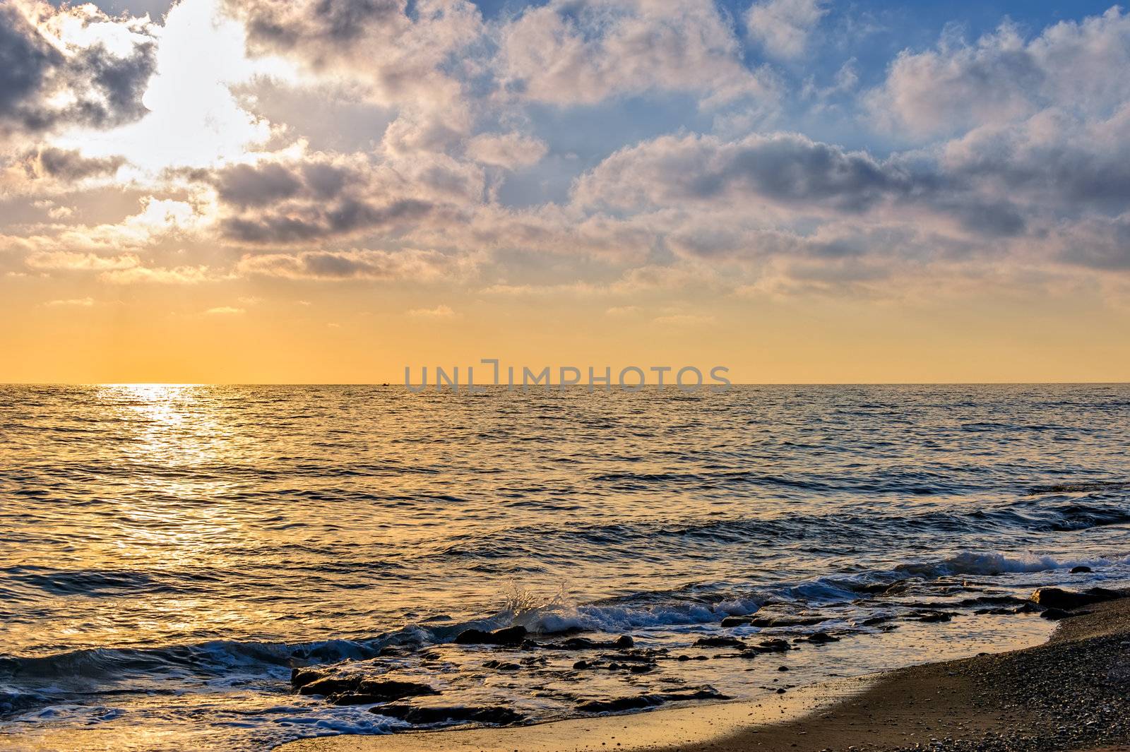 Sunset over the sea and pebble beach