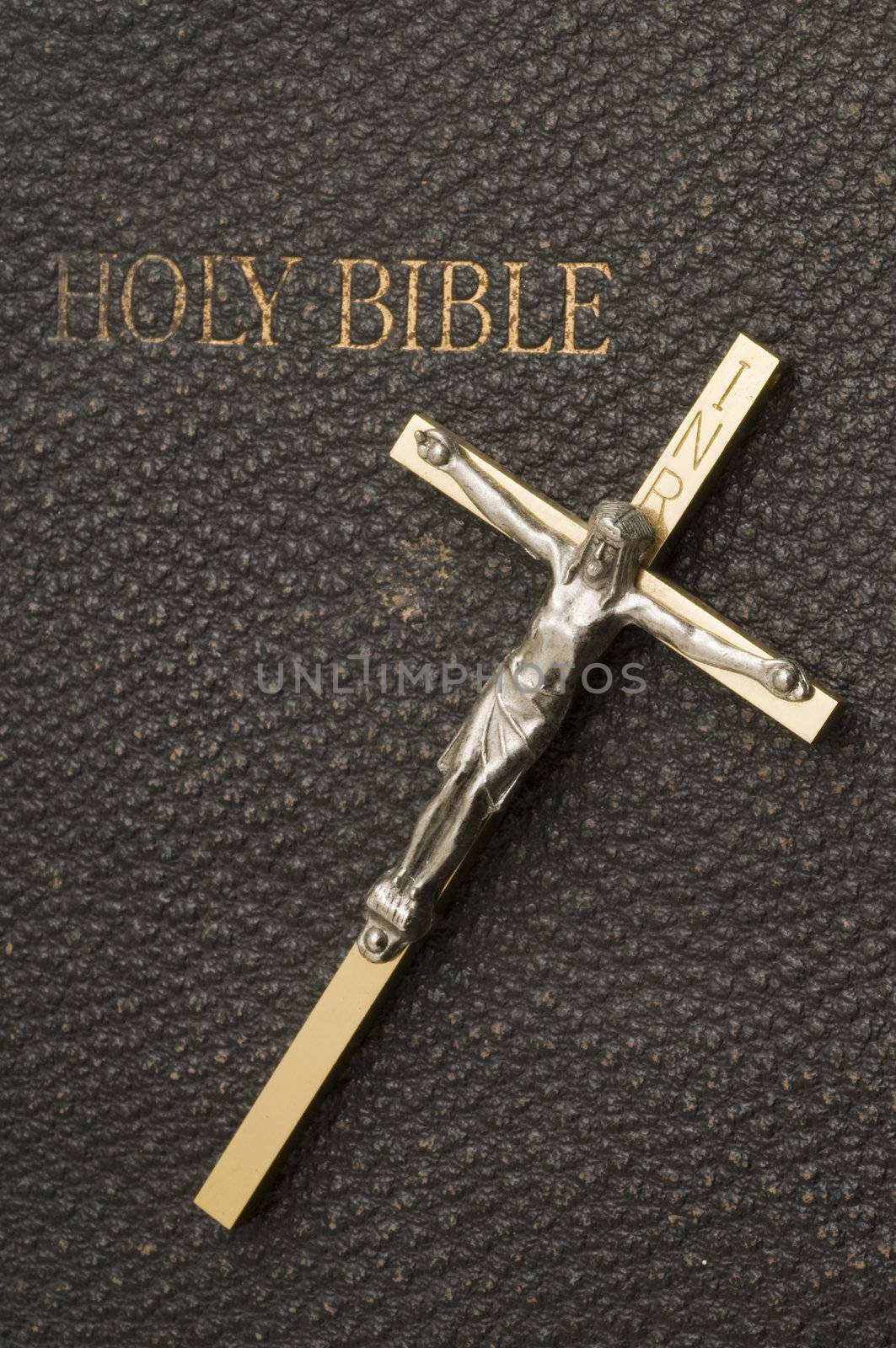 Macro photo of metal cross on antique bible cover