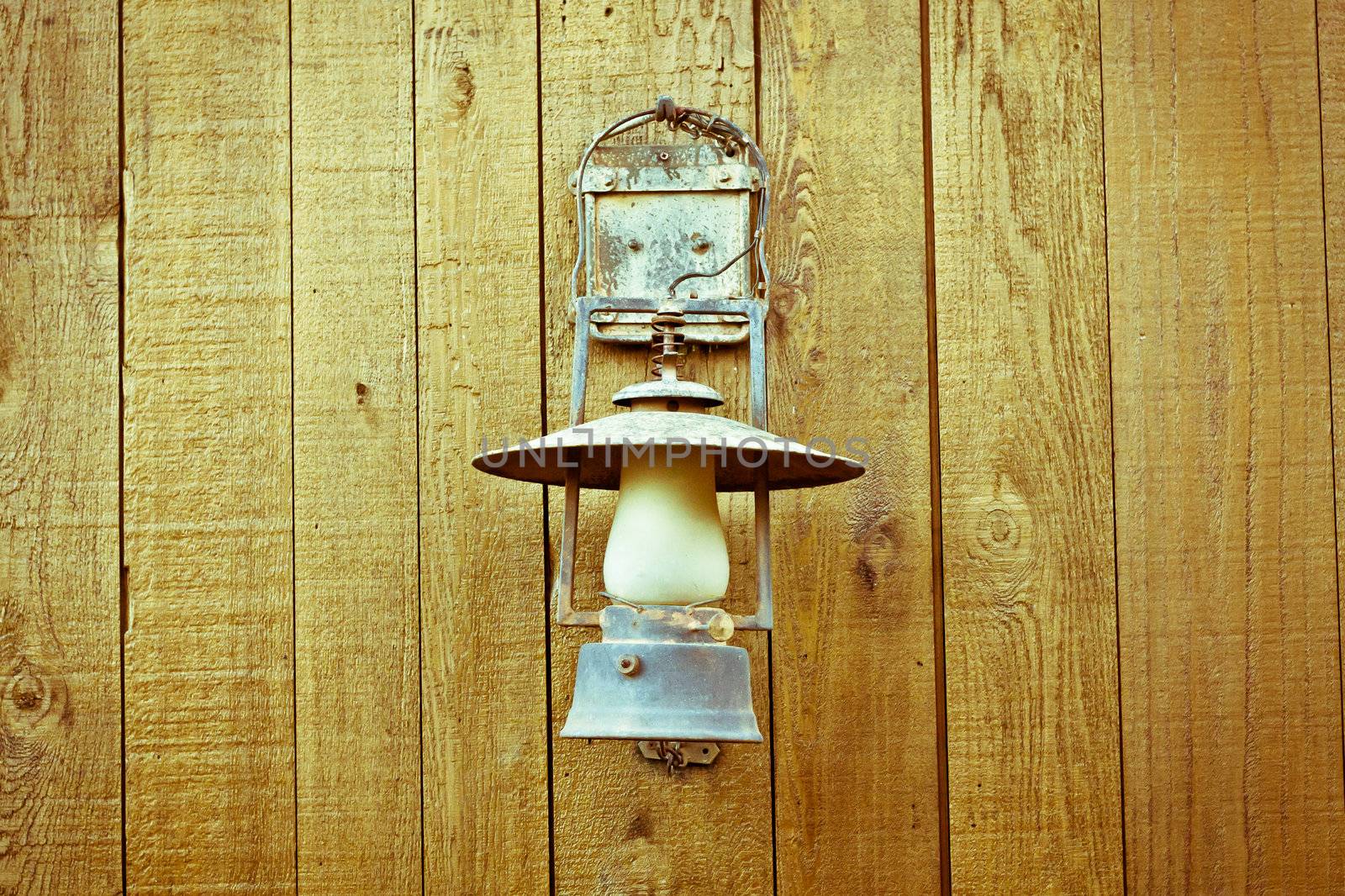 A nice vintage paraffin lamp mounted on a wooden wall