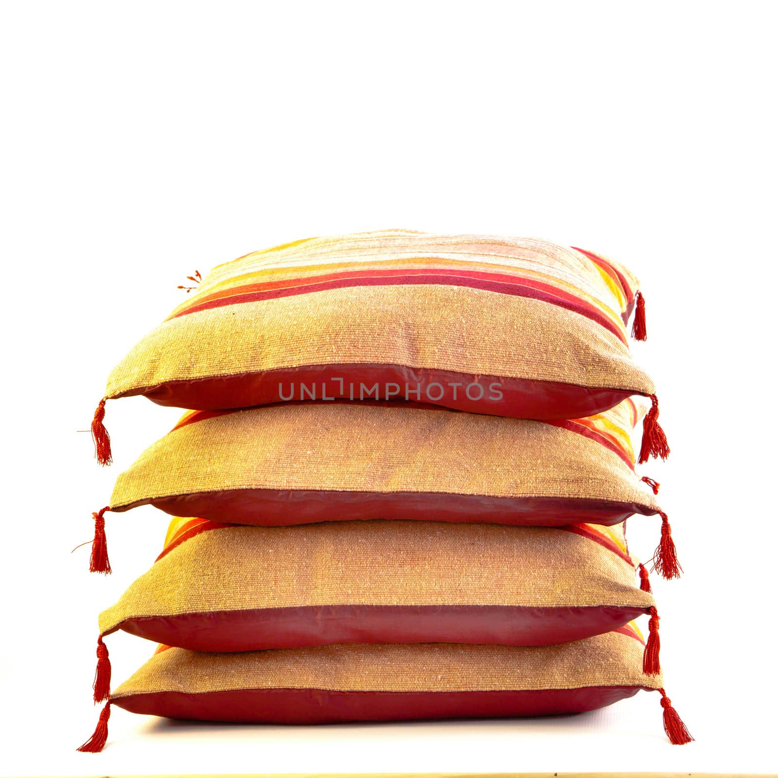 A stack of colorful moroccan cushions on a white background