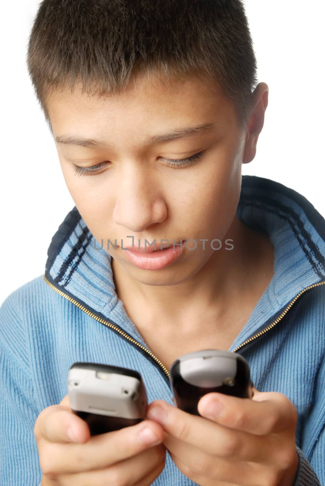 Boy with two telephones playing and typing SMS