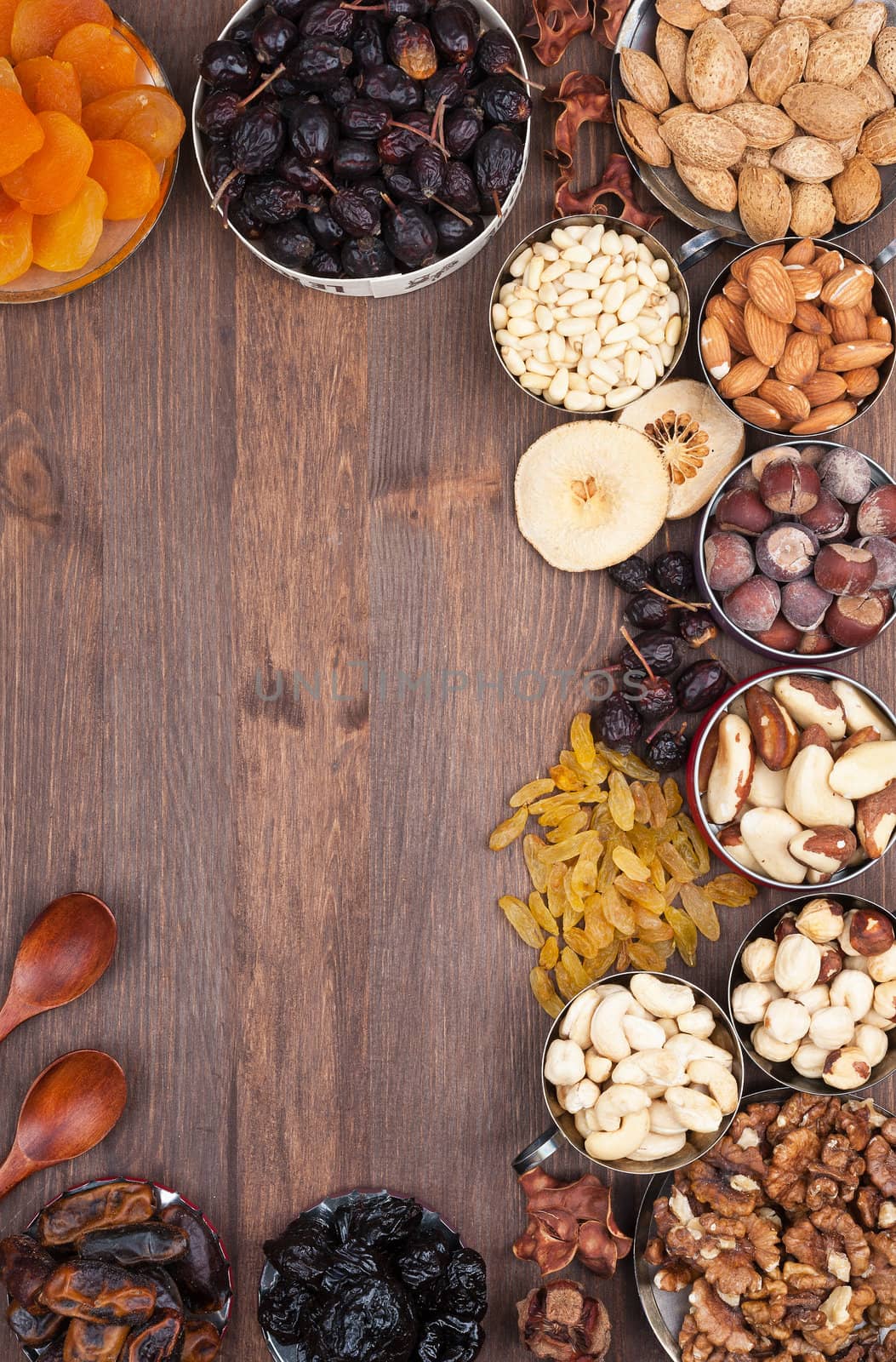 Frame of variety of fruits and nuts on a dark wooden surface