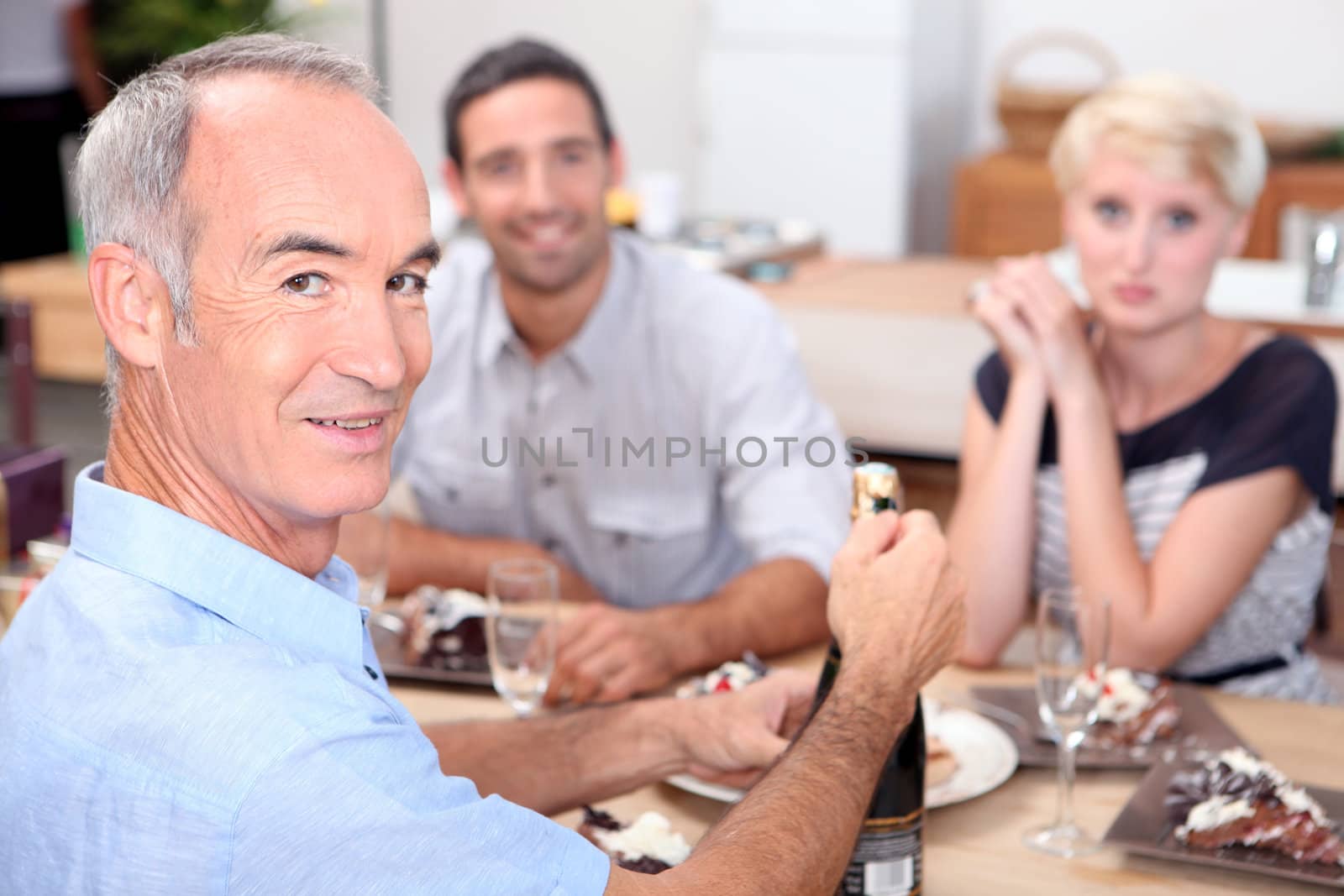 Family celebrating with champagne by phovoir