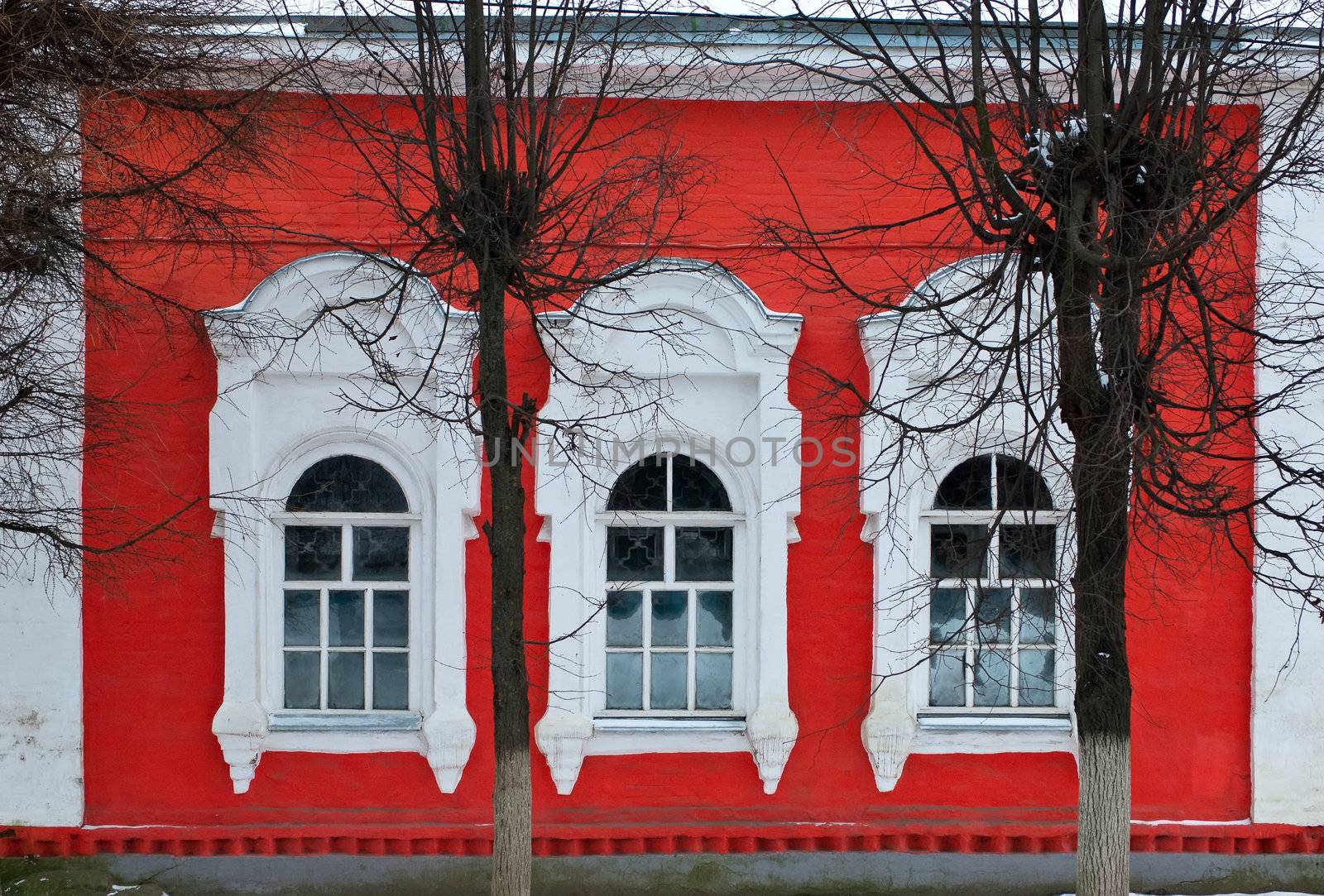 Red brick wall with three windows