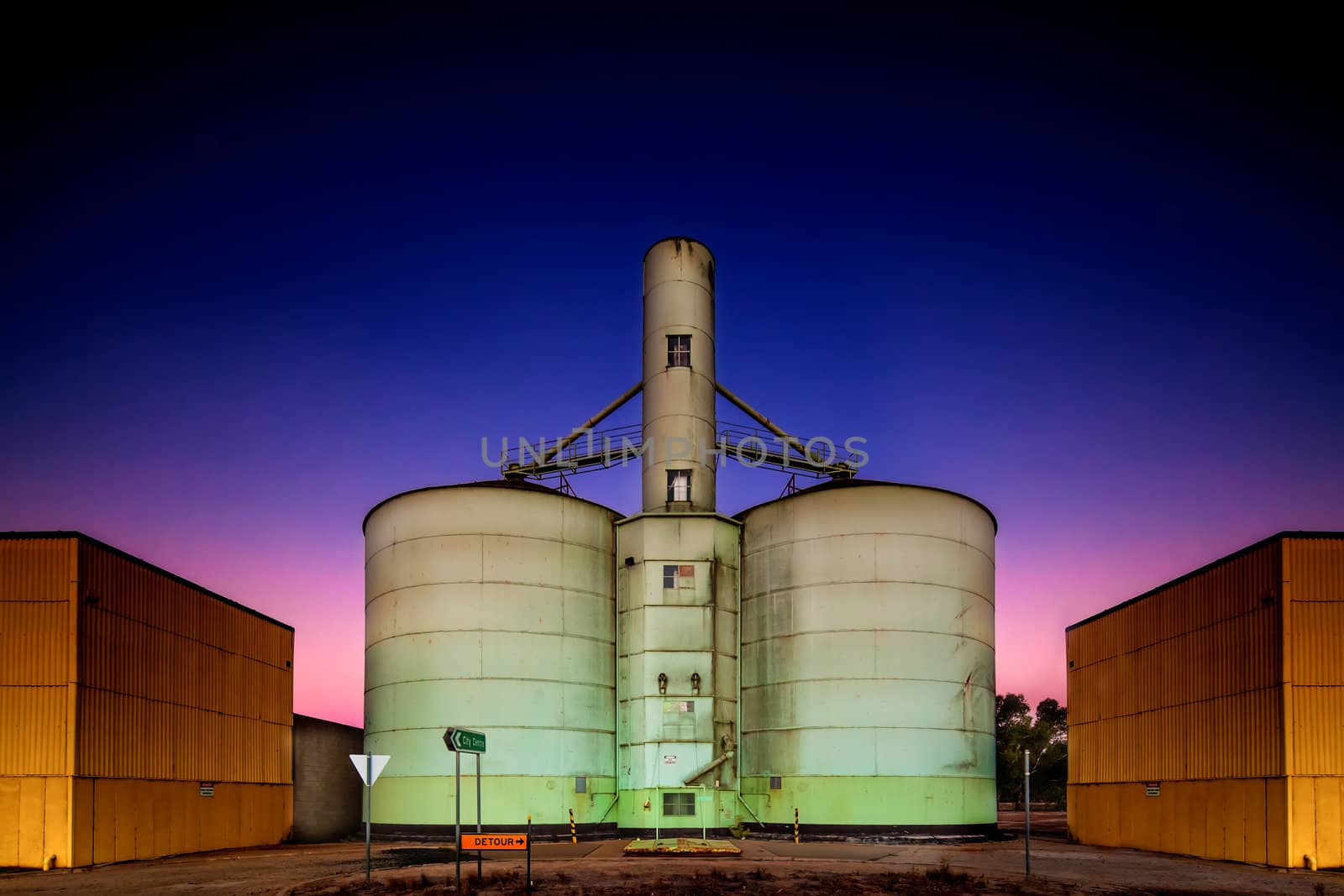 Old grain storage rustic silo during a stunning pink purple blue dusk sunset in country Victoria of Australia