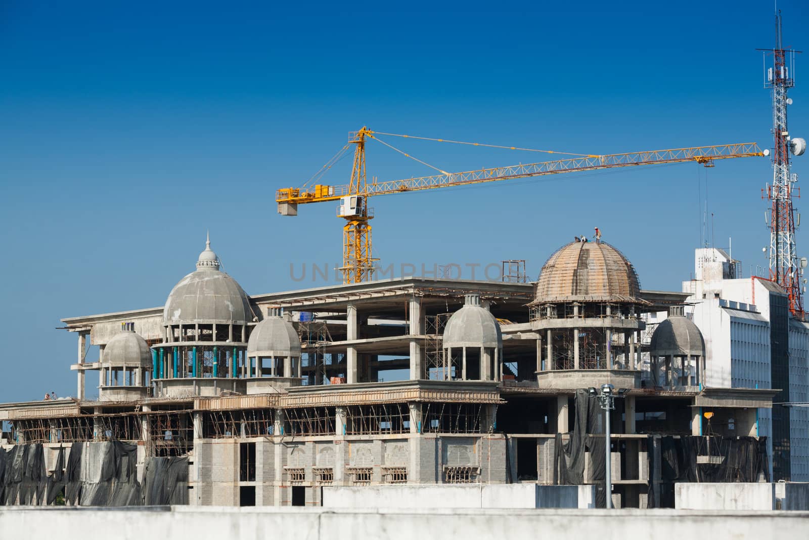 Construction of large buildings. Cranes are used to lift.