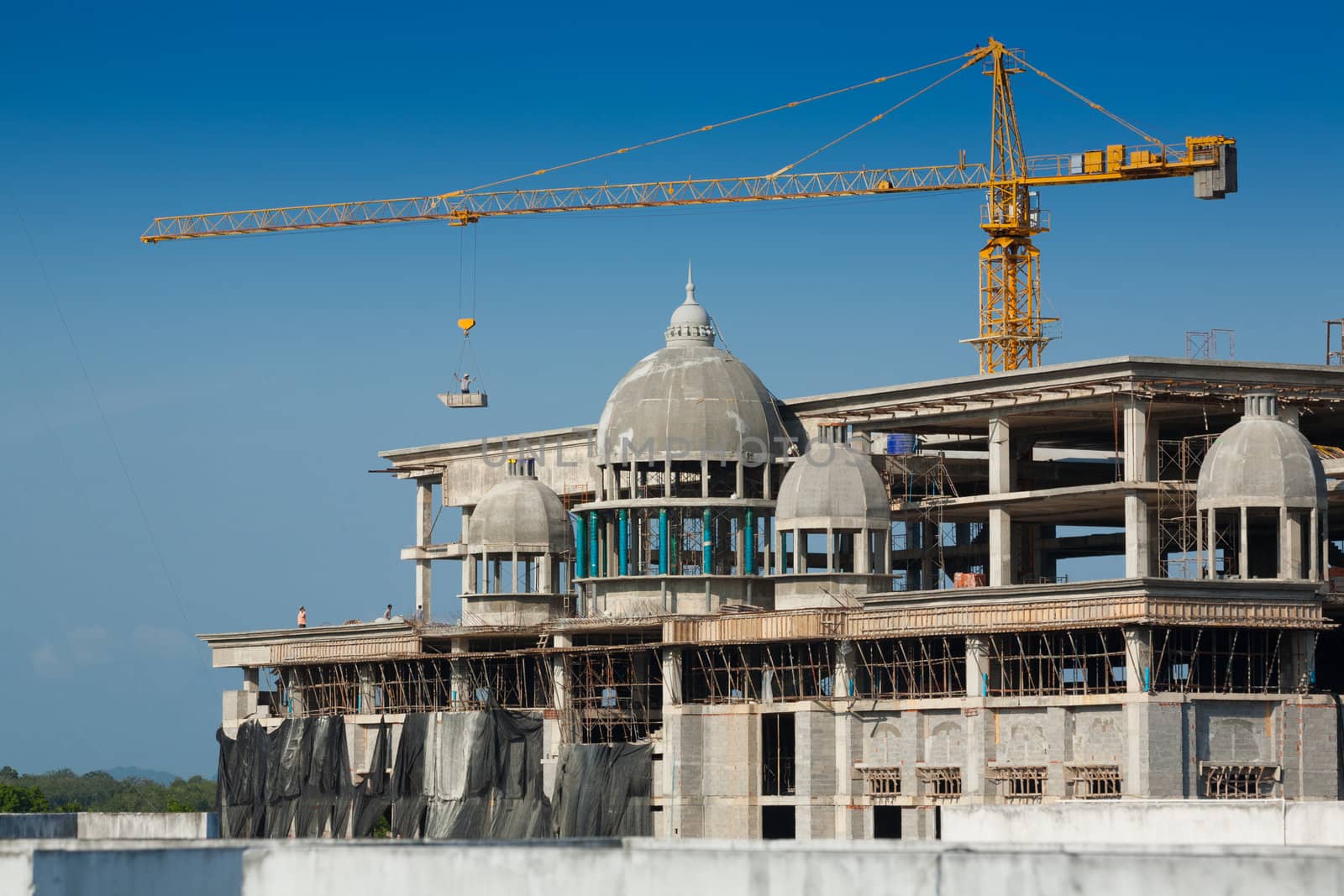 Construction of large buildings. Cranes are used to lift.