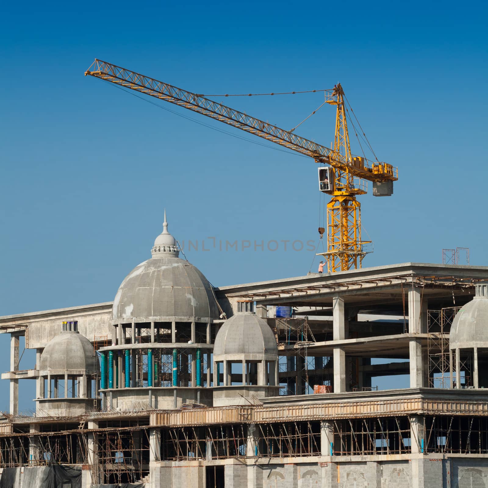 Construction of large buildings. Cranes are used to lift.
