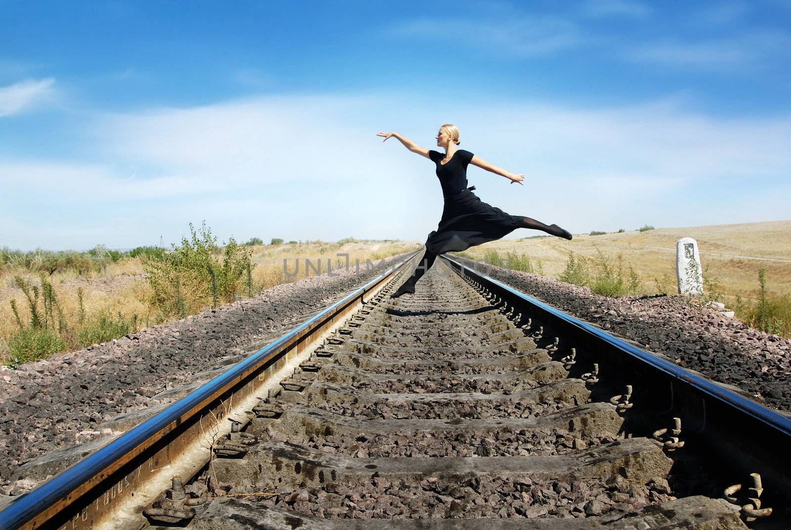 Ballet dancer jumping over the railway