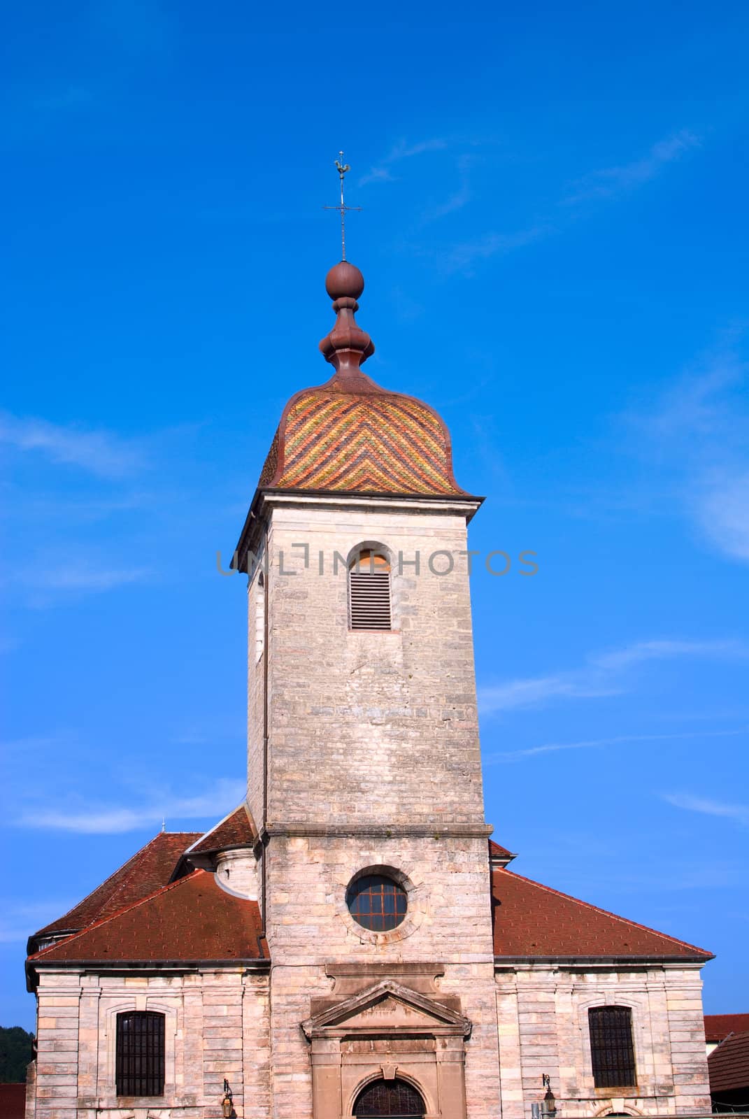 french church with tower on blue sky