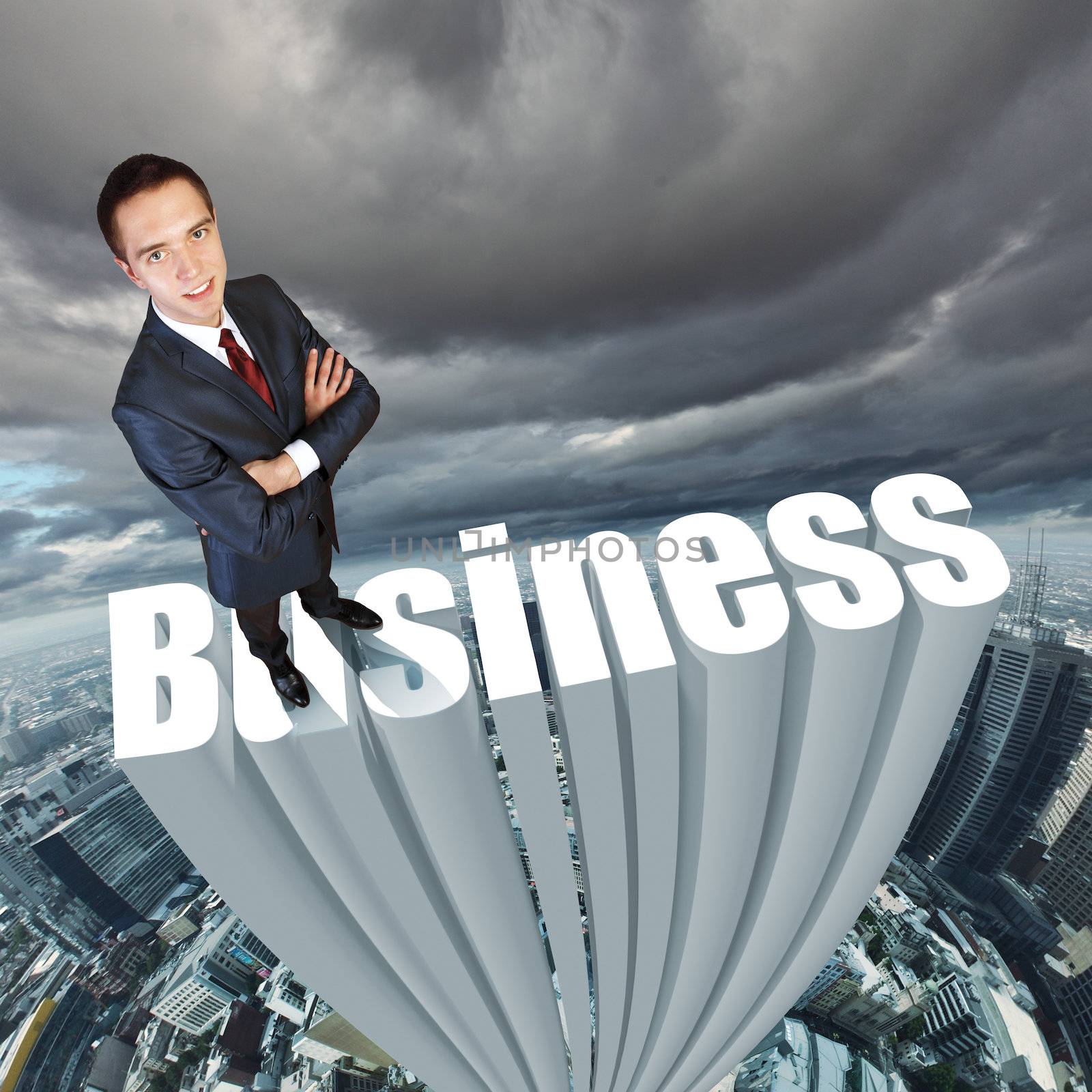 Businessman in suit standing on the word Business