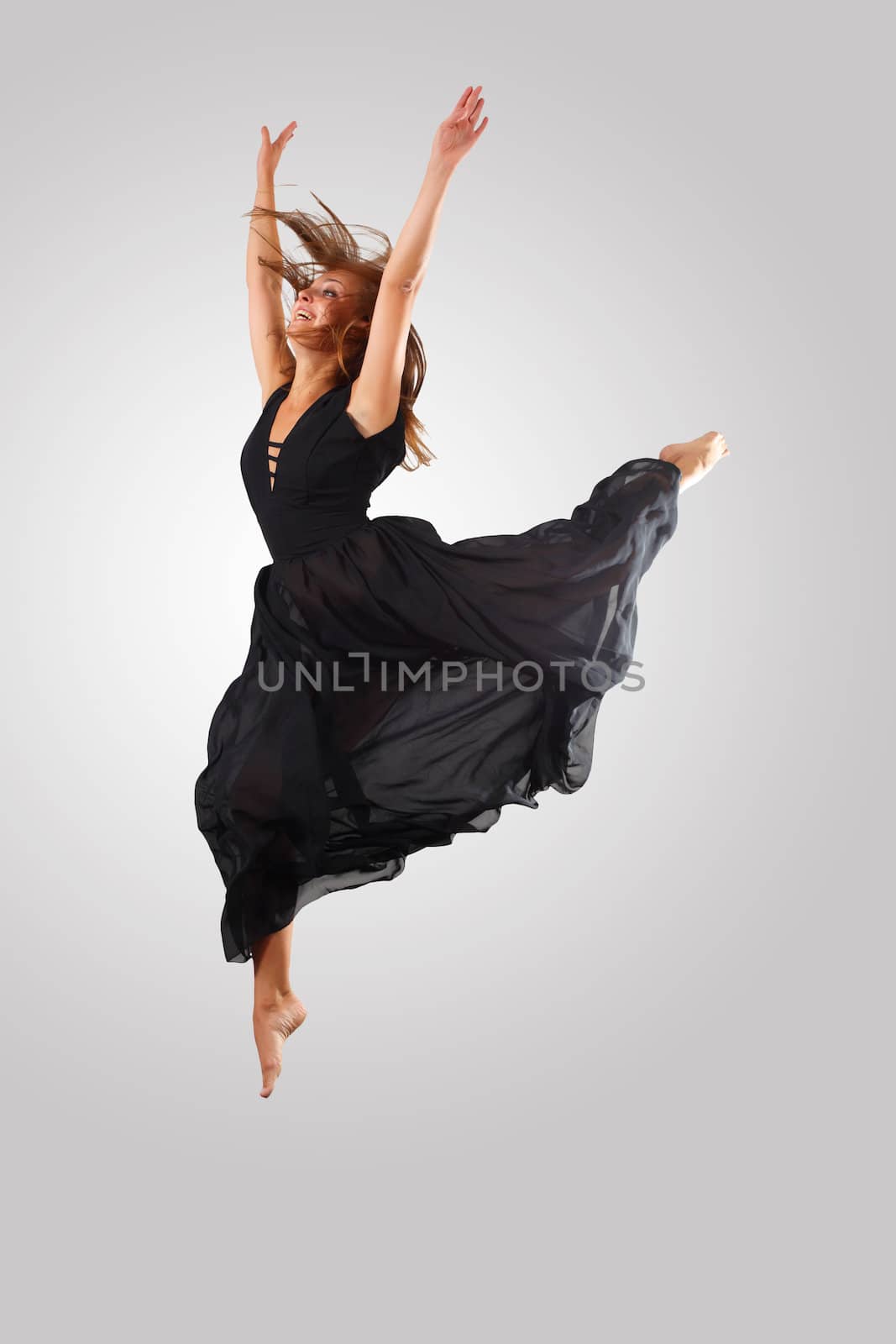 Young female dancer jumping against white background