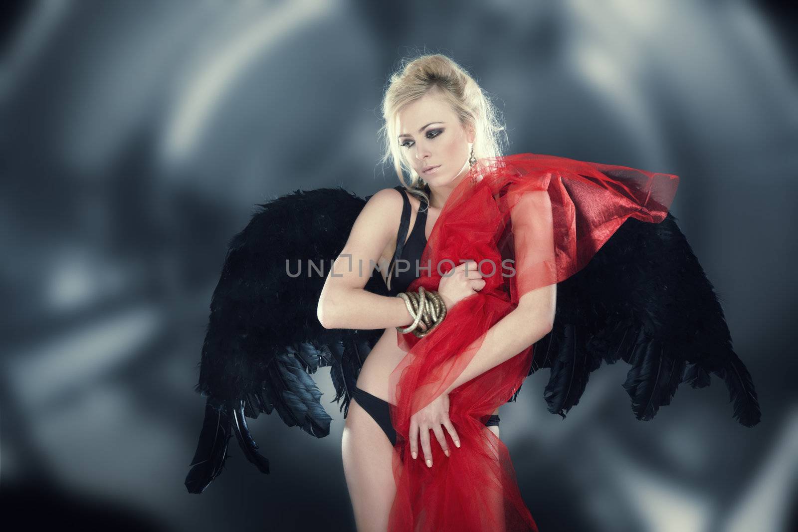 Blond female angel with black wings on abstract background