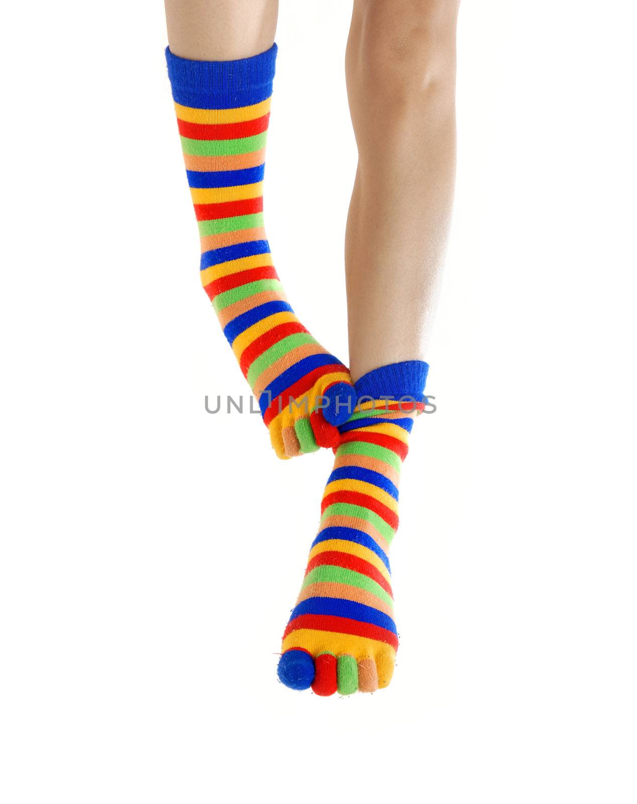 Thin legs in colored socks scratching each other