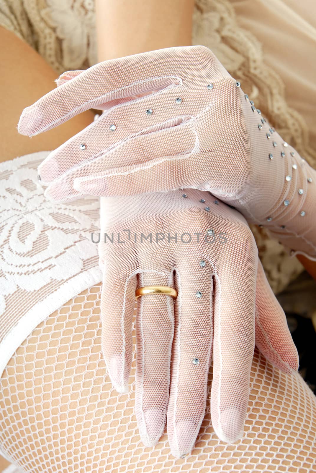 Close-up photo of the bridal hands in gloves and sexy hip in stocking