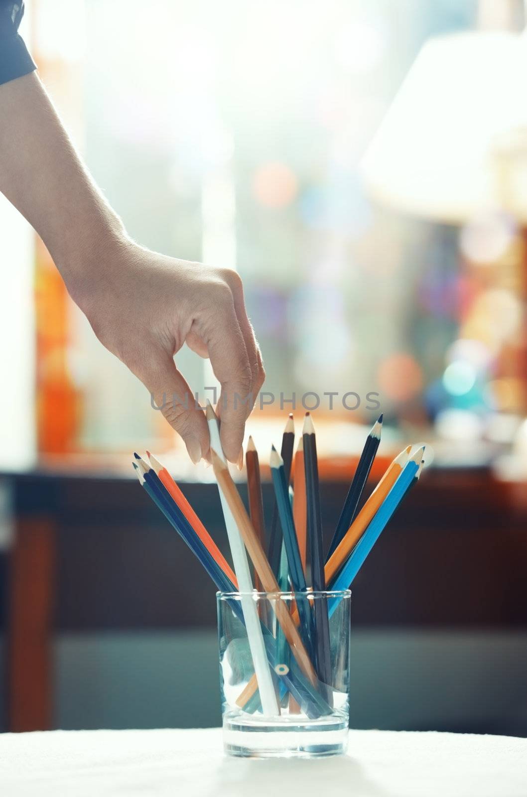 Human hand taking taking pencils