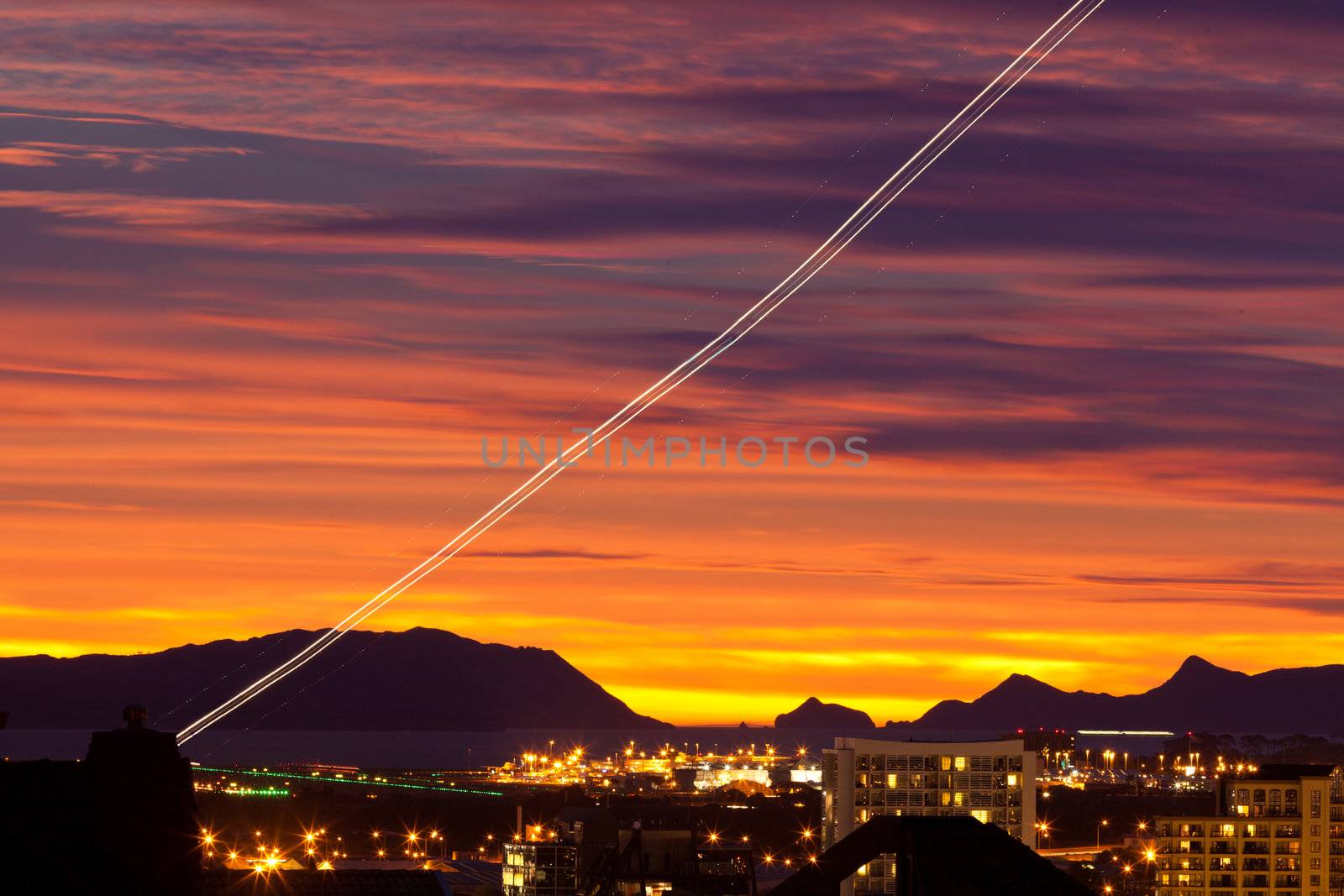 Sunset and light trail of starting airplane over Manukau southern suburb of Auckland New Zealand