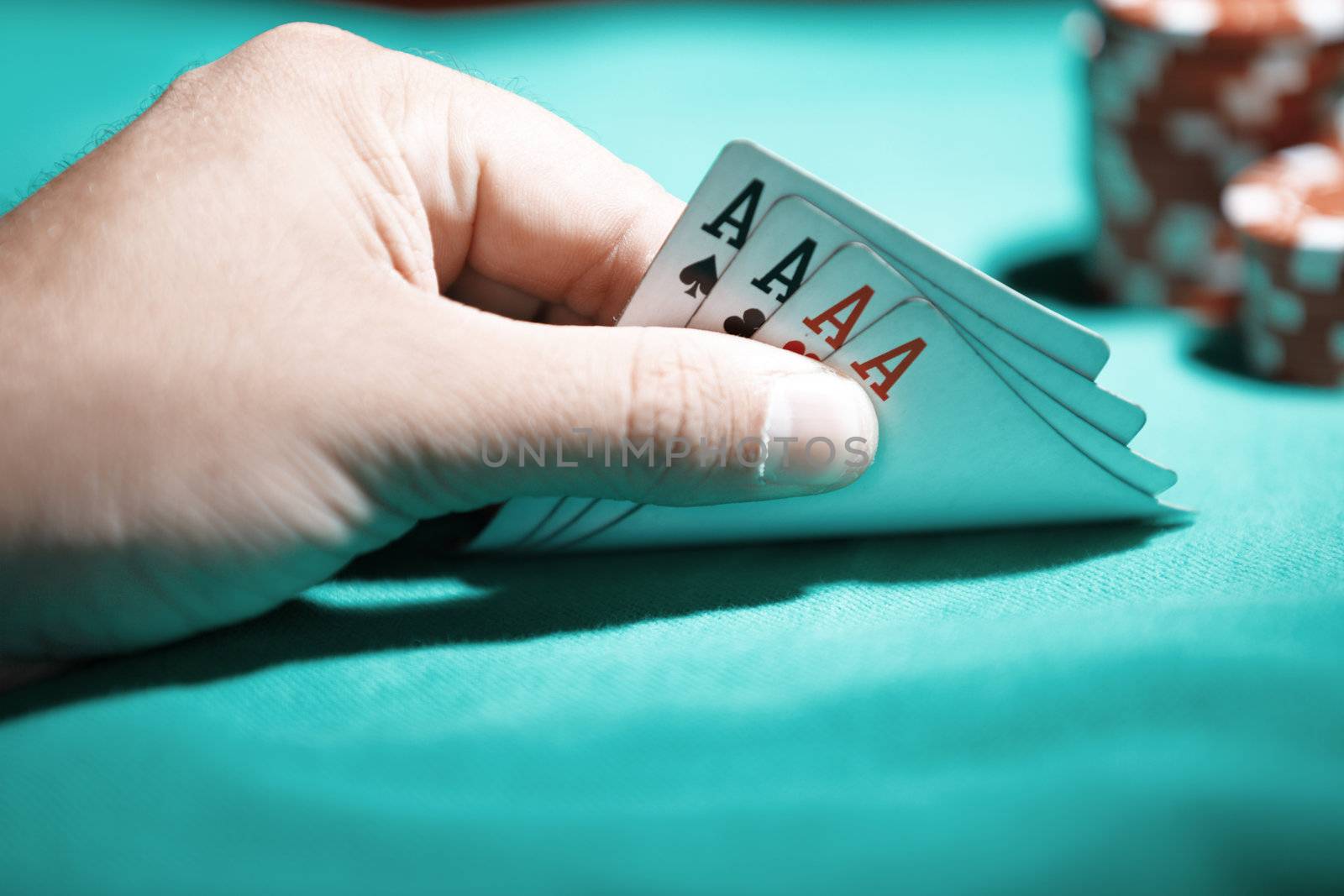 Human hand holding cards with four of aces