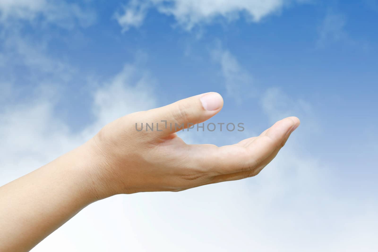 Male hand held up with blue sky and cloud.