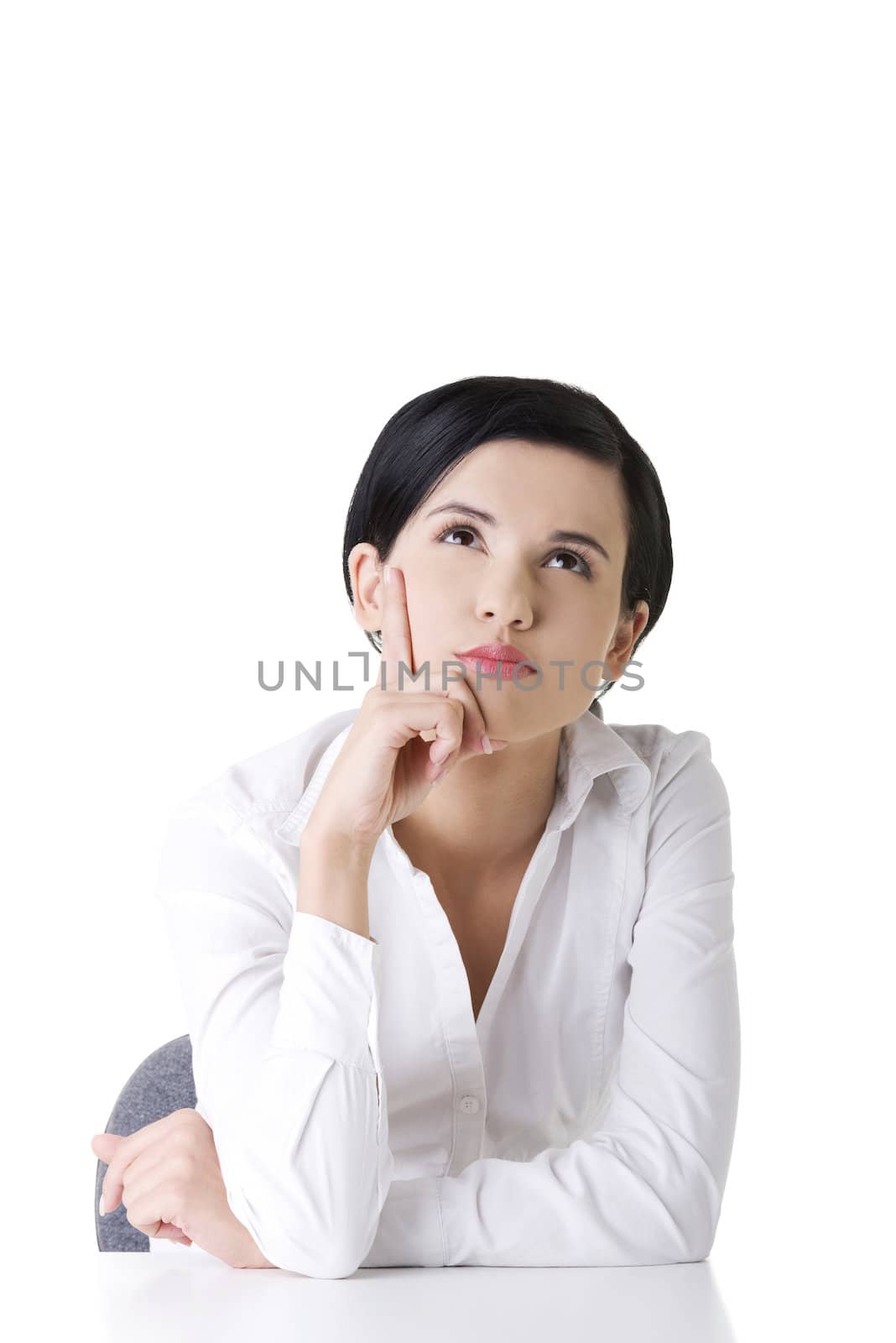 Pretty young woman in sitting at the desk, isolated on white