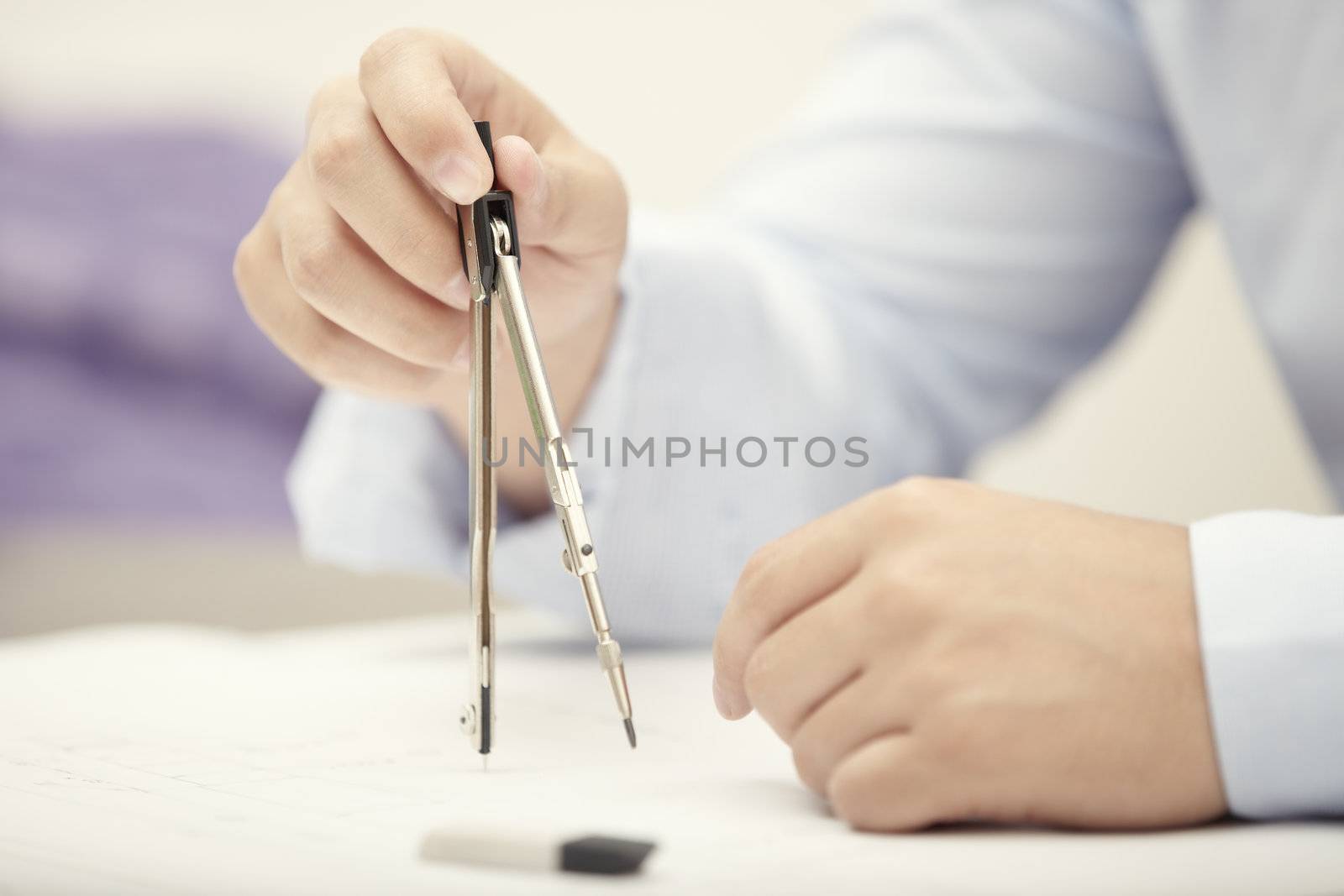 Hands of engineer working with compasses