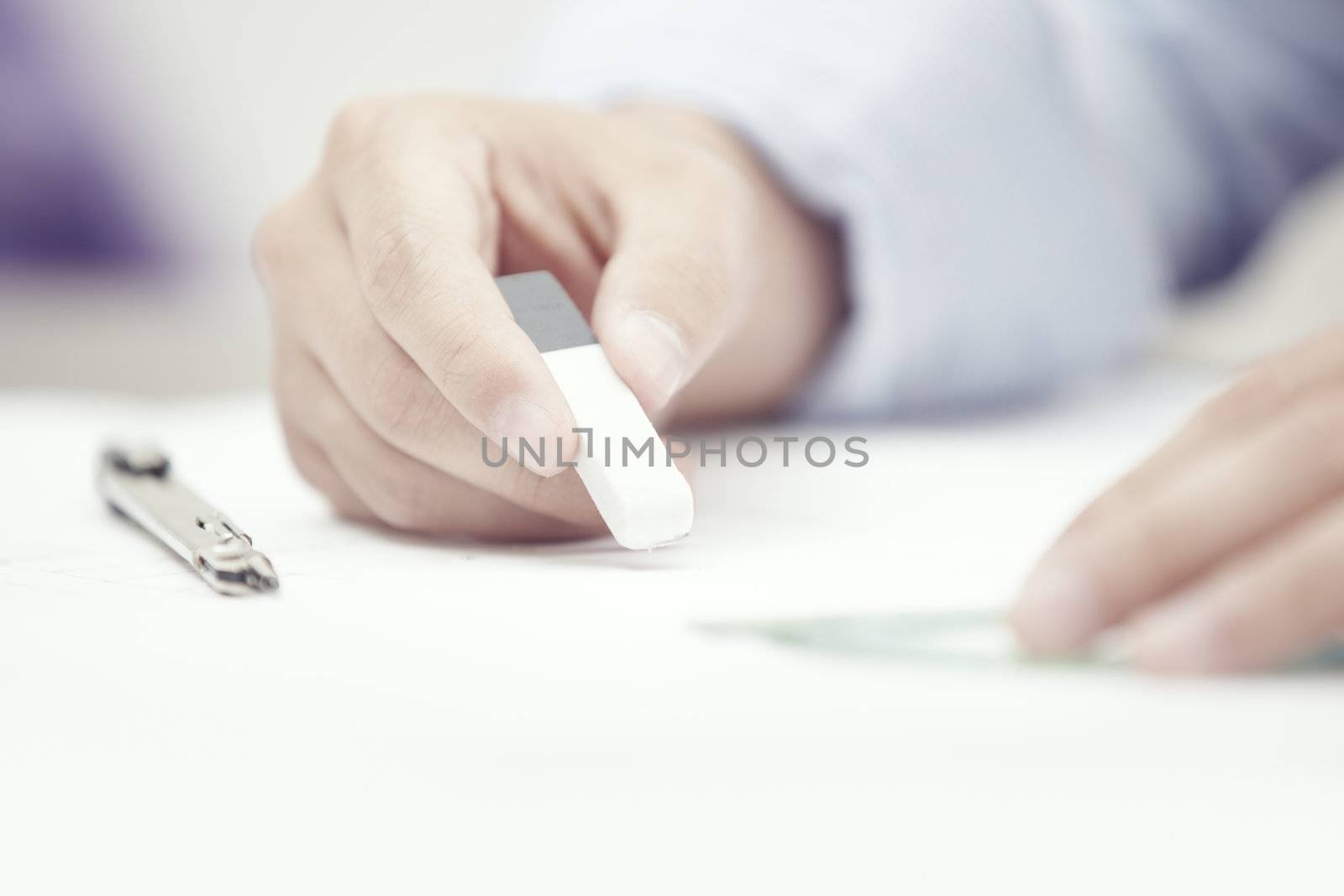 Hand of engineer using rubber eraser