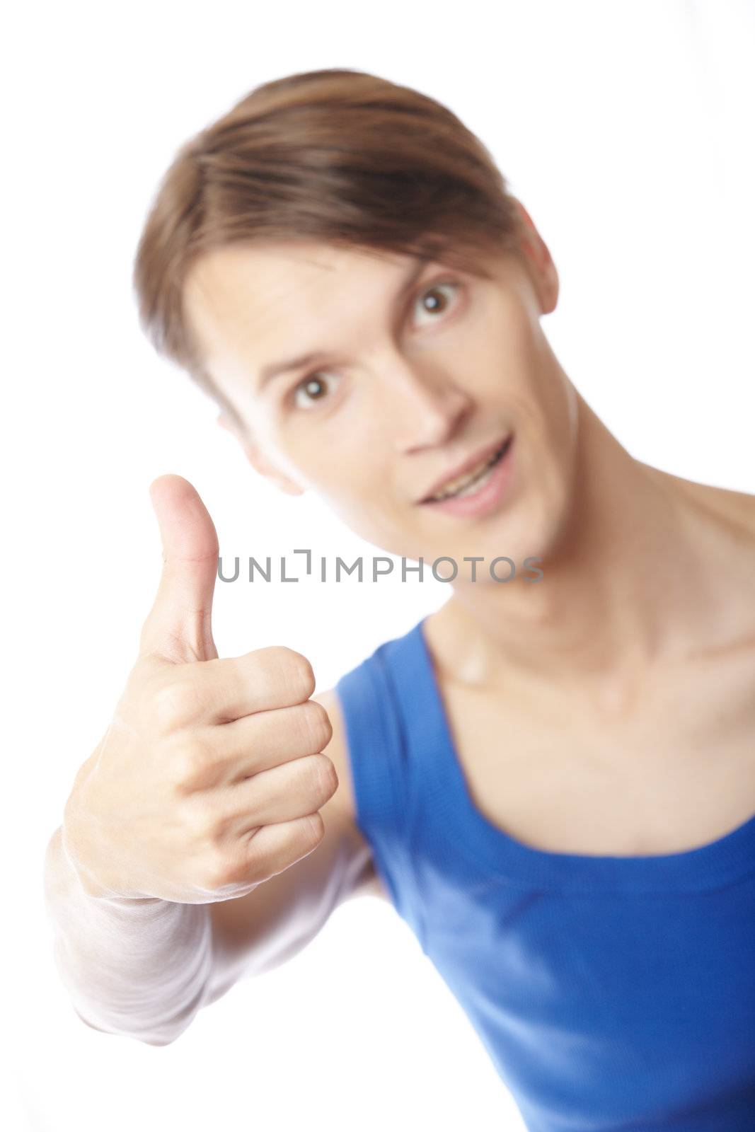 Young sportive man making thumbs up on a white background