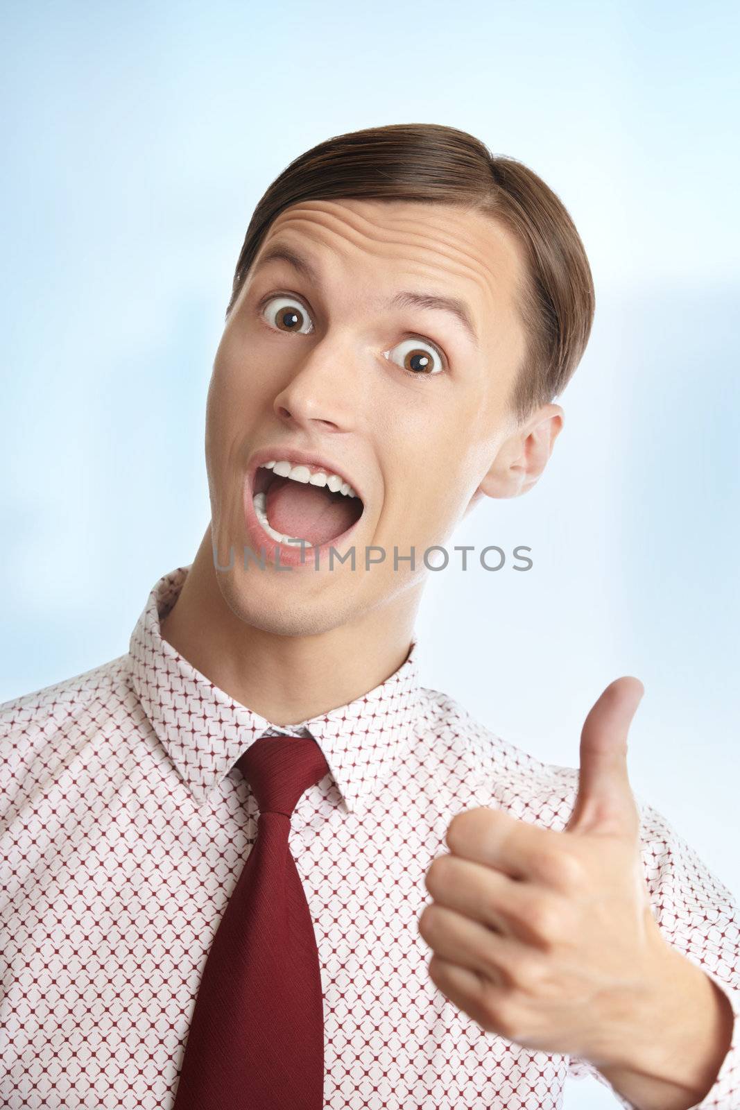 Successful businessman making thumbs up gesture on a blue background