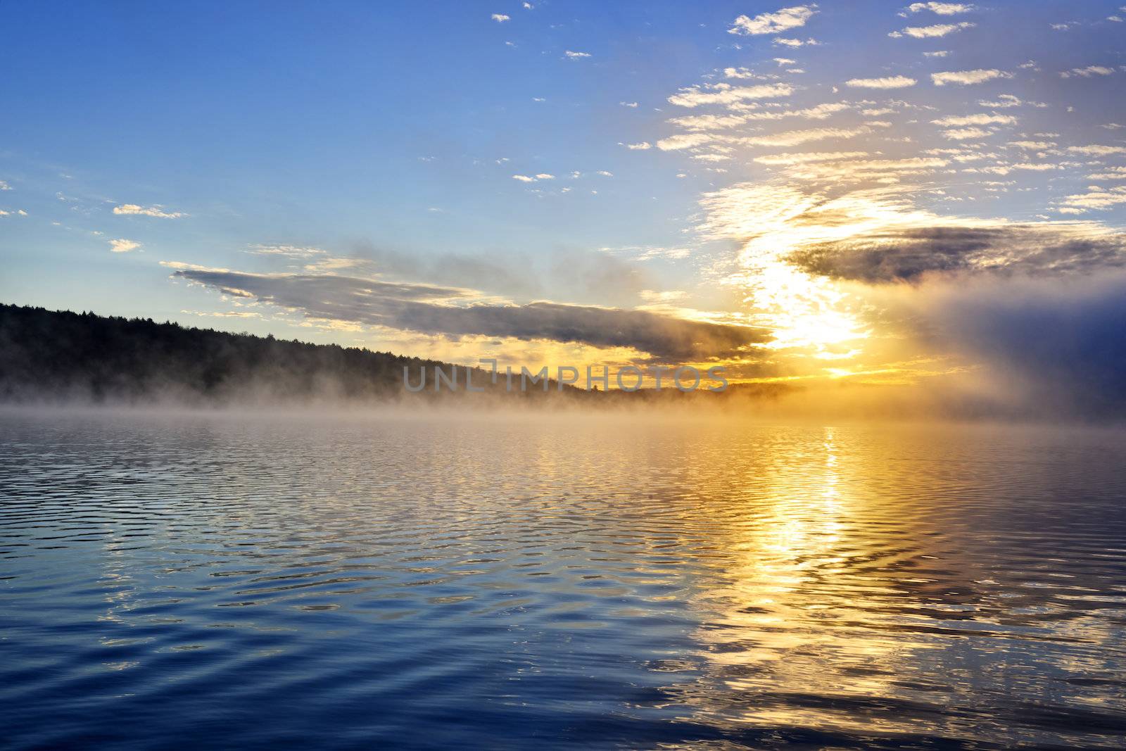 Sun rising over foggy lake in Algonquin Park, Canada