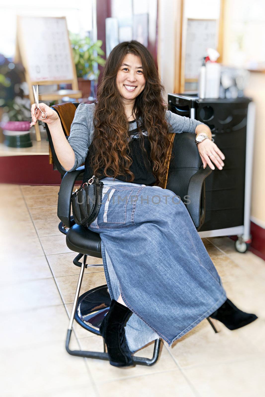 Hairstylist sitting in a chair in her hair salon
