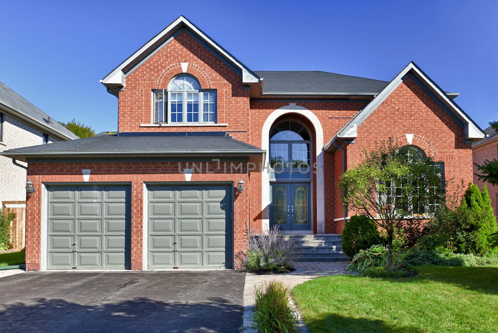 Brick house in suburbs with two car garage