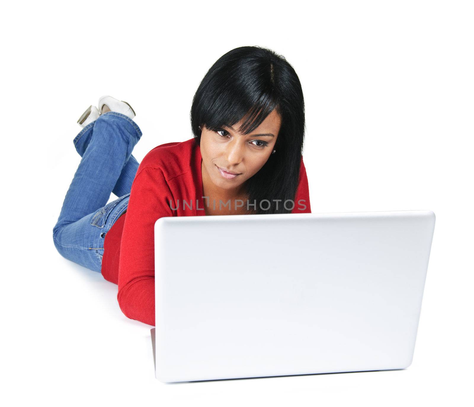 Black young woman typing on computer laying on floor