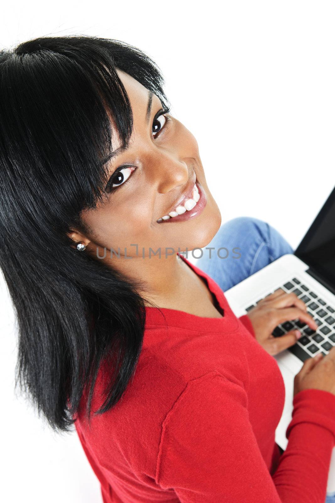 Smiling black woman looking up and typing on computer