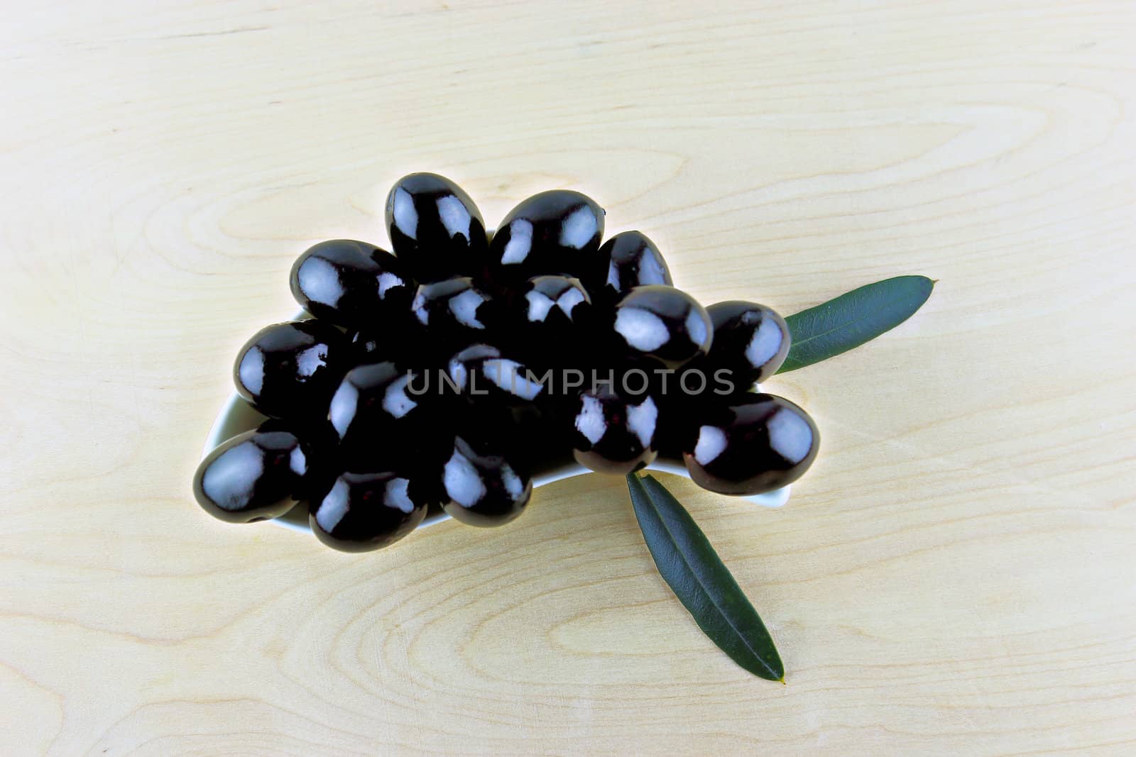 Black Olives with leaves on a white background