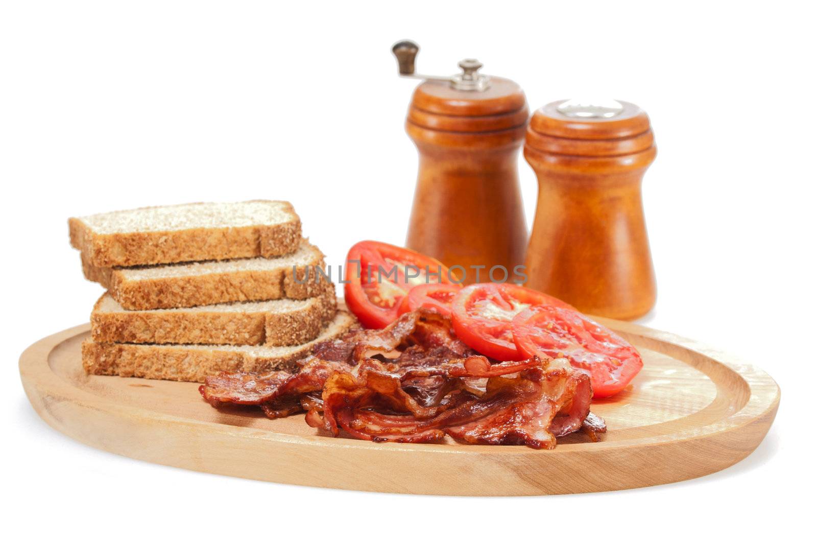 Platter of cooked bacon and fresh tomatoes on a white background.