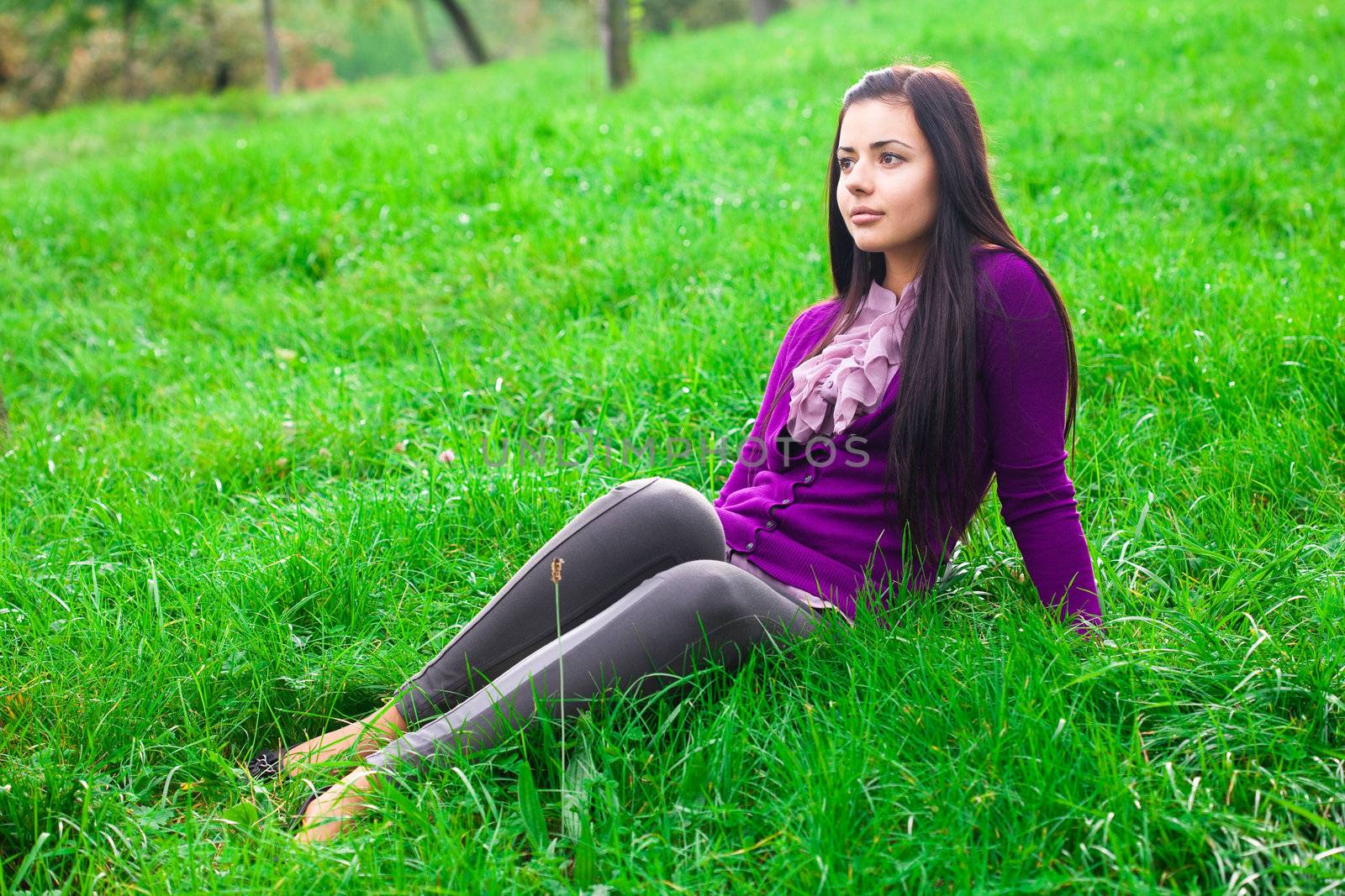 beautiful young woman lying on green grass