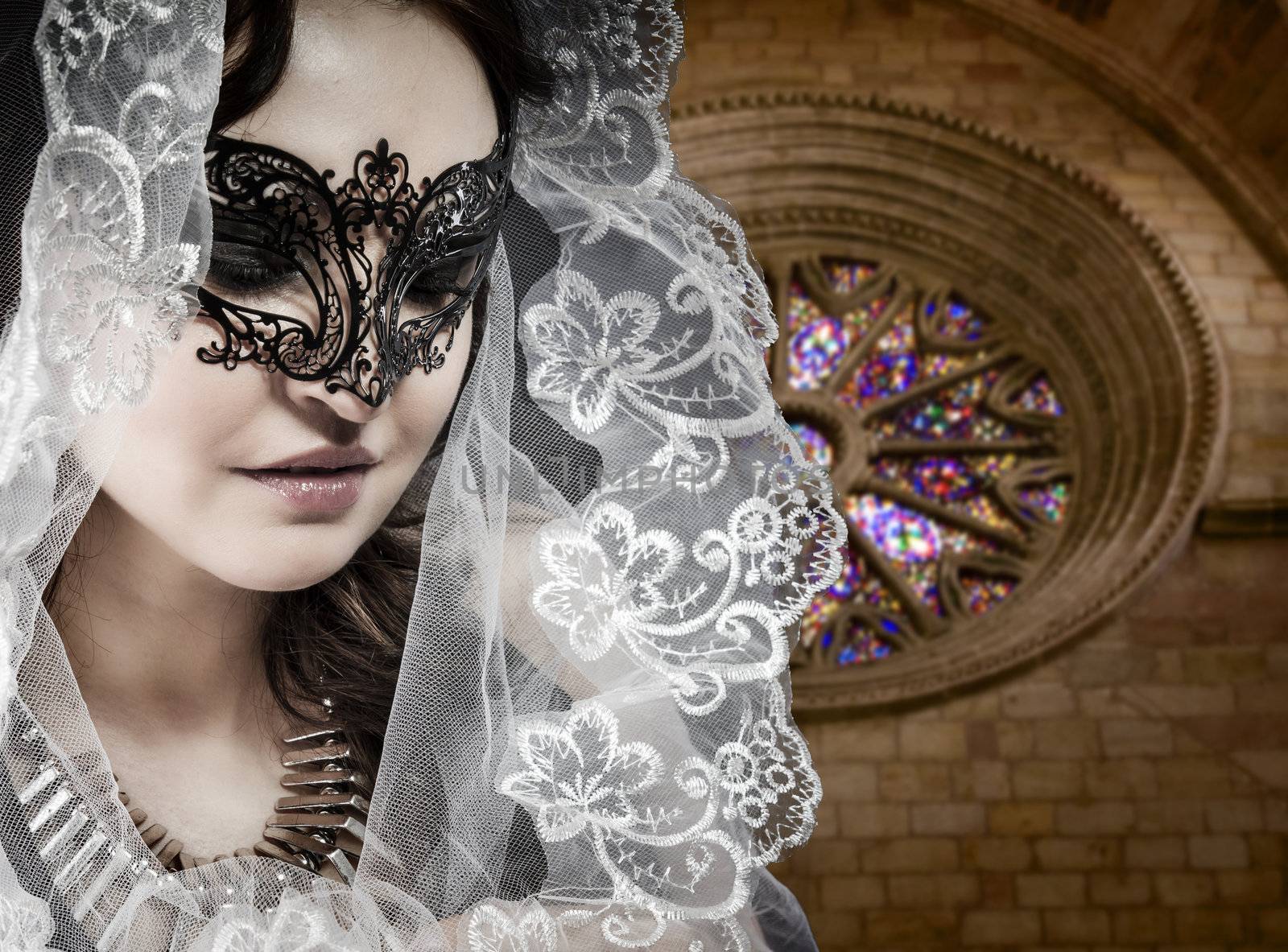 Virgin, Woman in veil and black dress with venetian mask in gothic cathedral