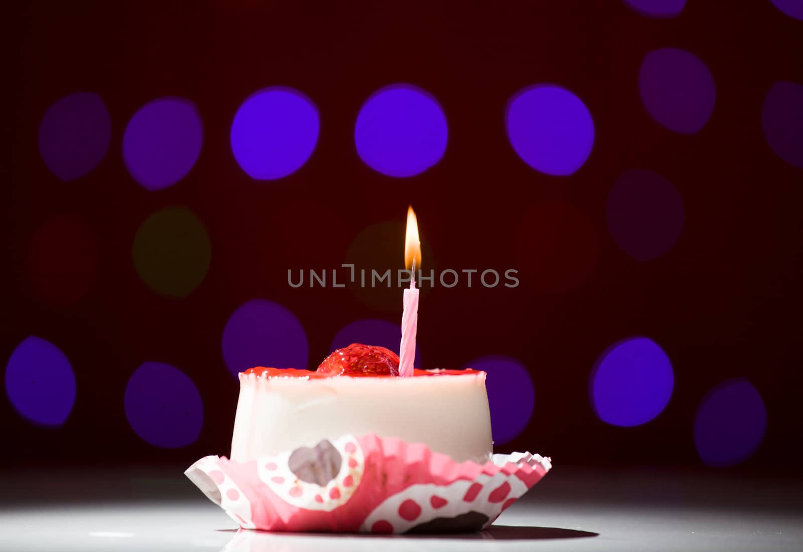 happy birthday cake shot on a red blurred background with candles