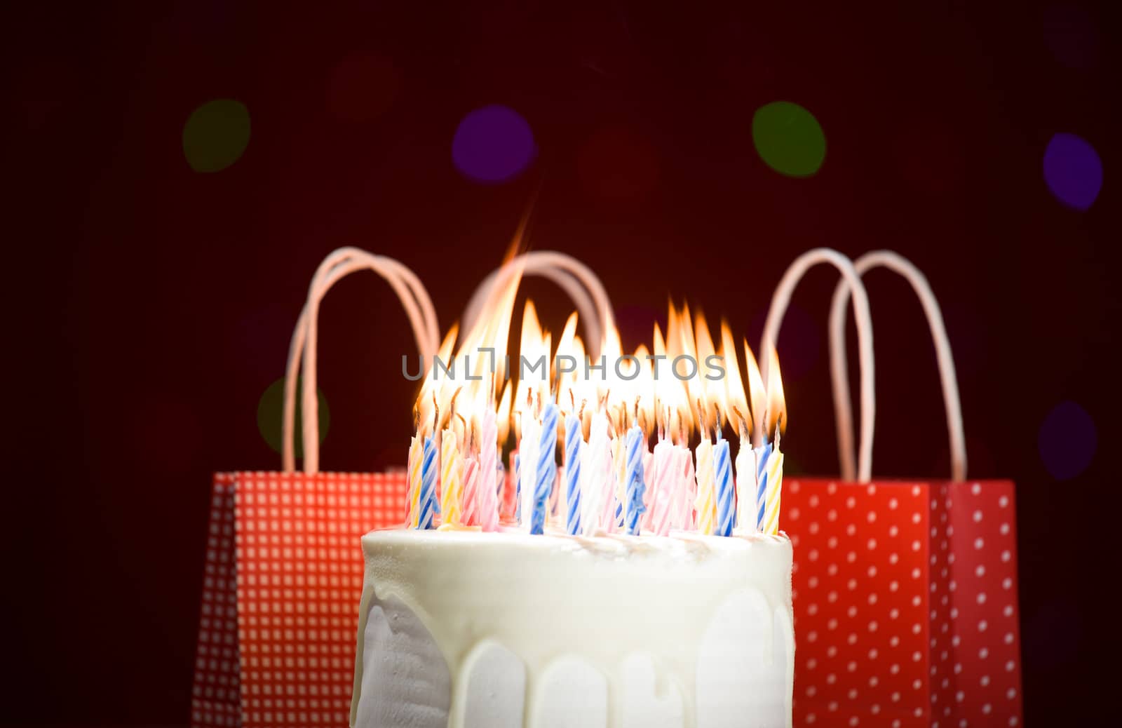 happy birthday cake shot on a red blurred background with candles