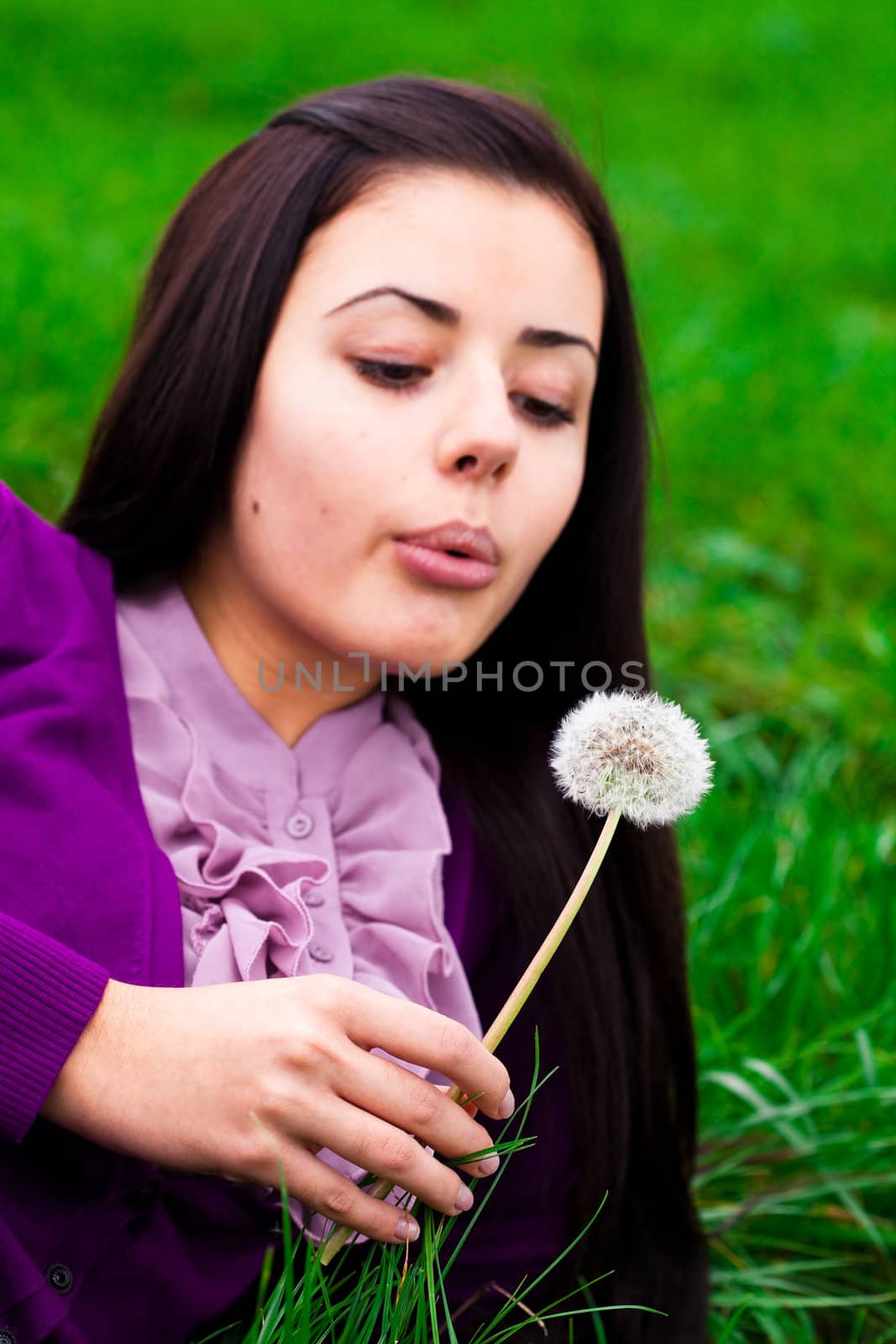 portrait of a beautiful young woman with dandelion