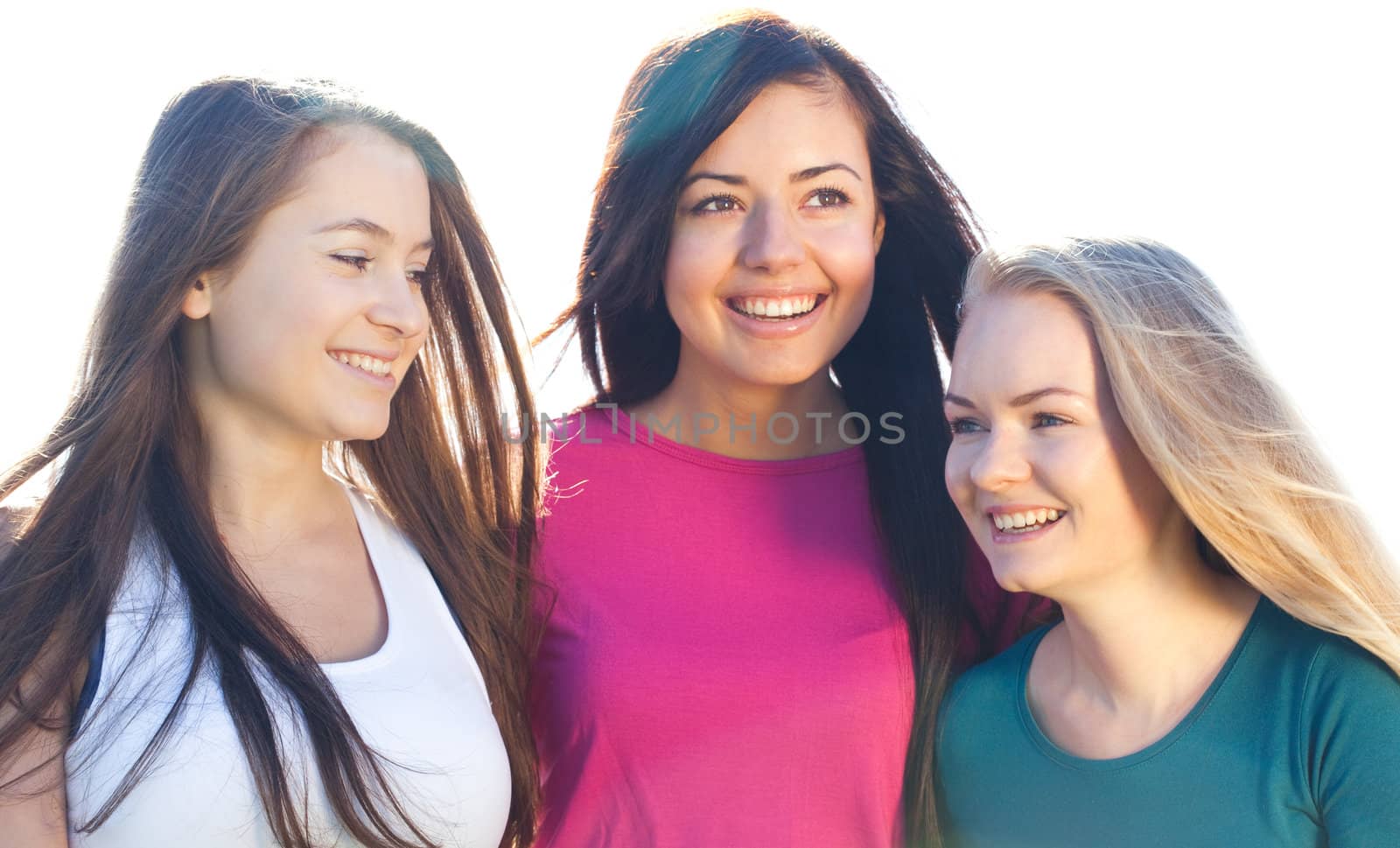 portret of three young beautiful woman on the  sky background 