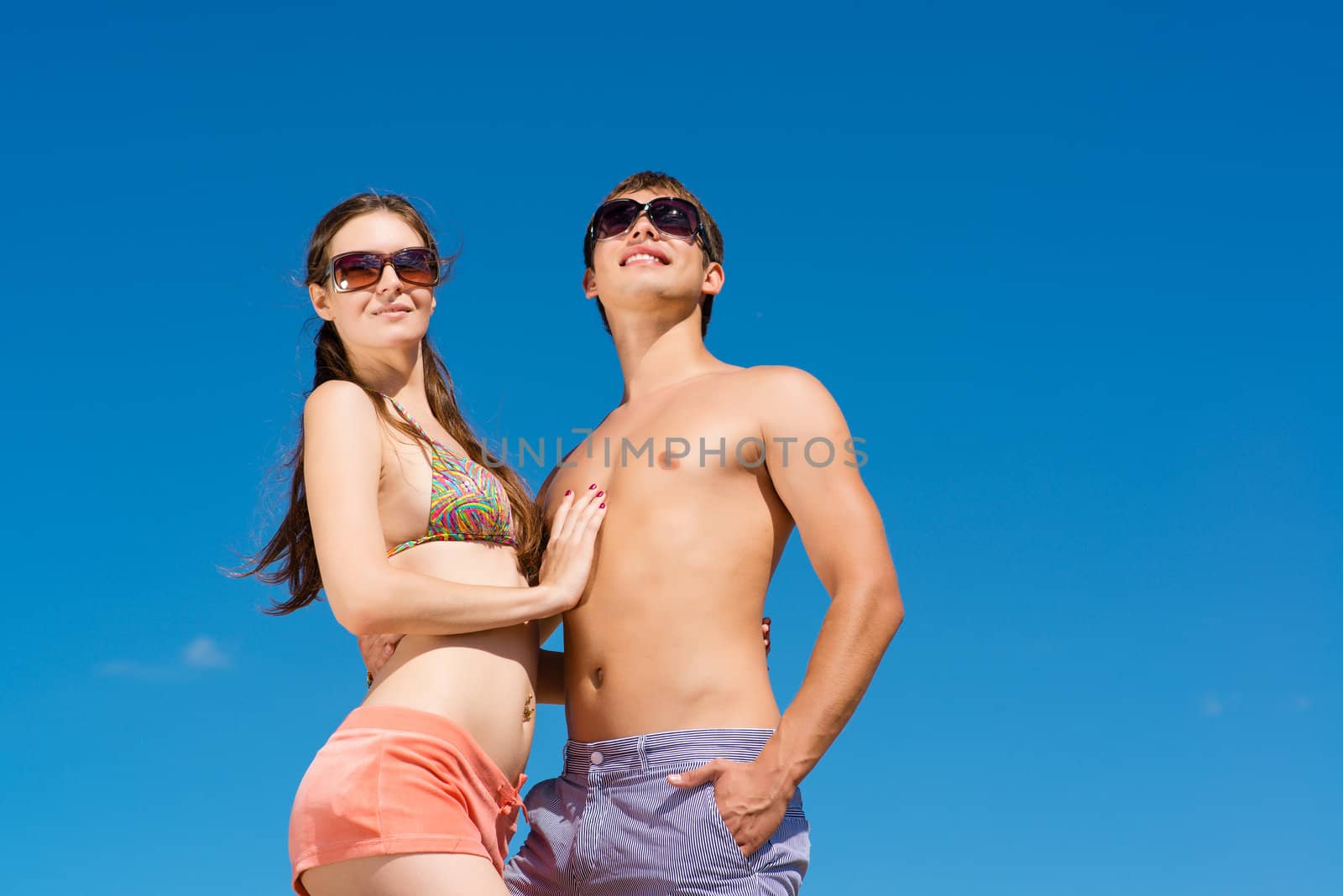 Young couple hugging on a background of blue sky, hold together honeymoon