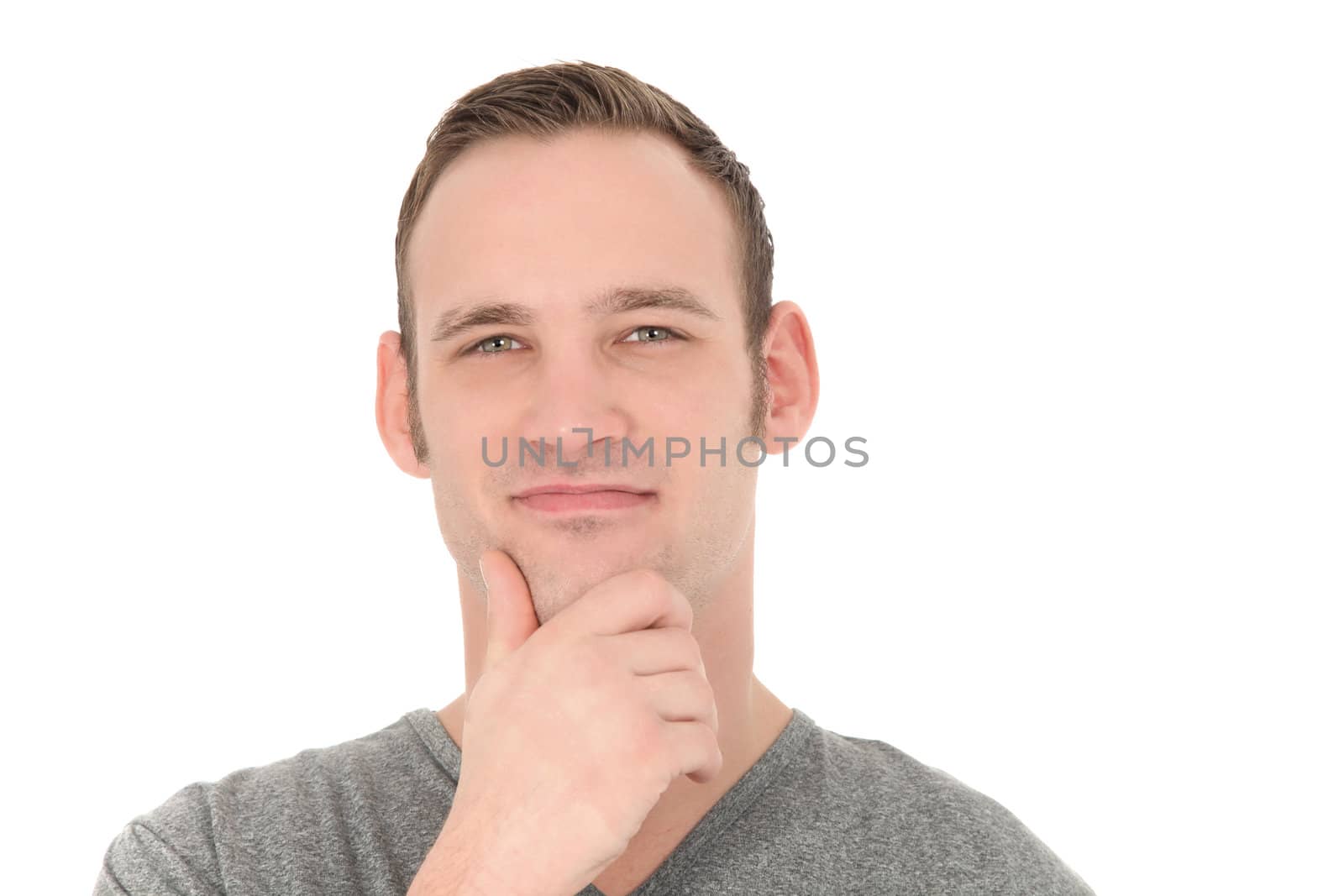 Thoughtful young man looking directly at the camera with his hand to his chin isolated on white