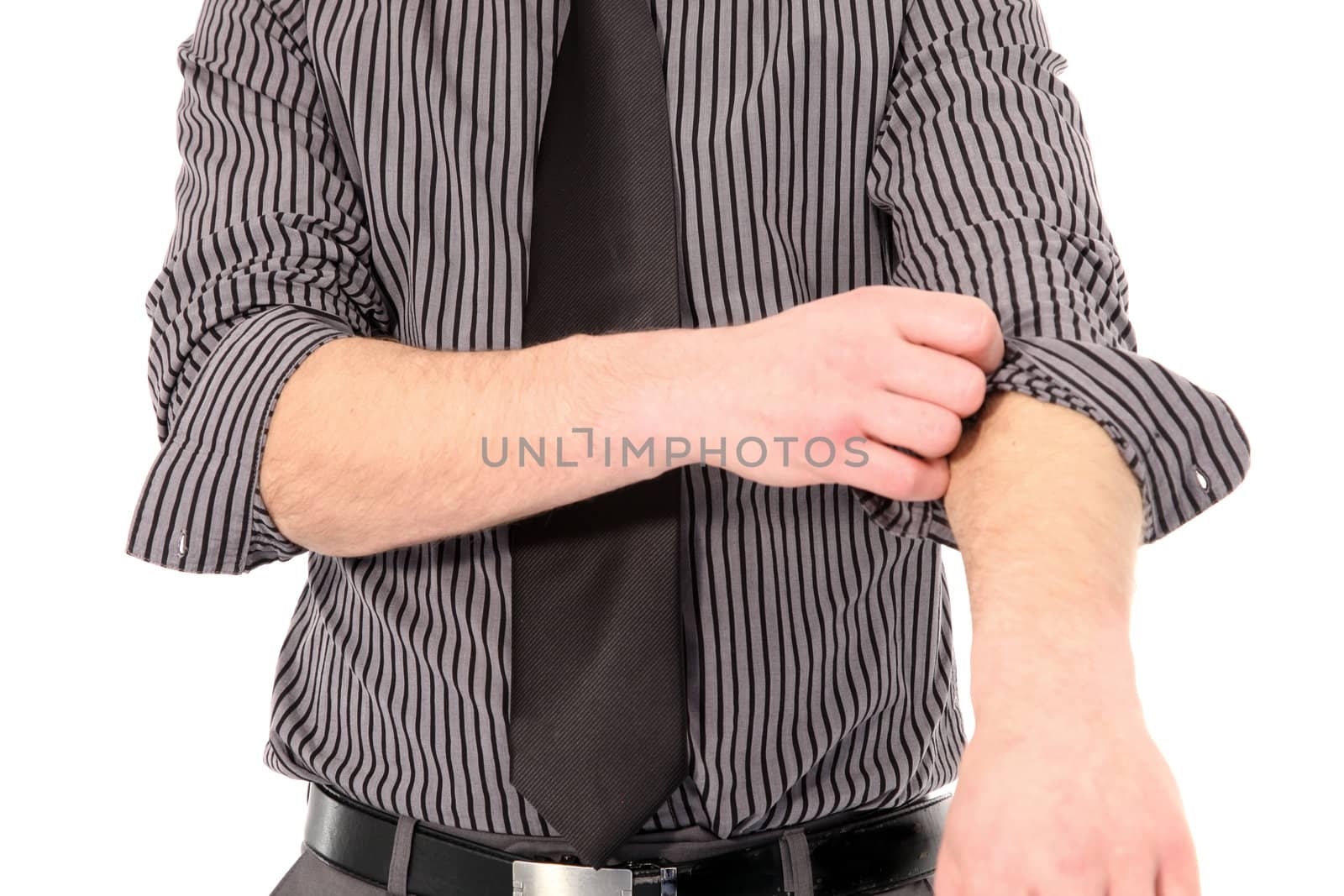 Cropped torso portrait of a young man in a tie rolling up his shirt sleeves isolated on white
