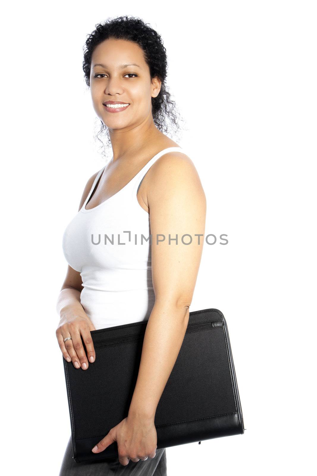 Beautiful casual young African American woman carrying a large black leather file under her arm standing sideways smiling at the camera isolated on white